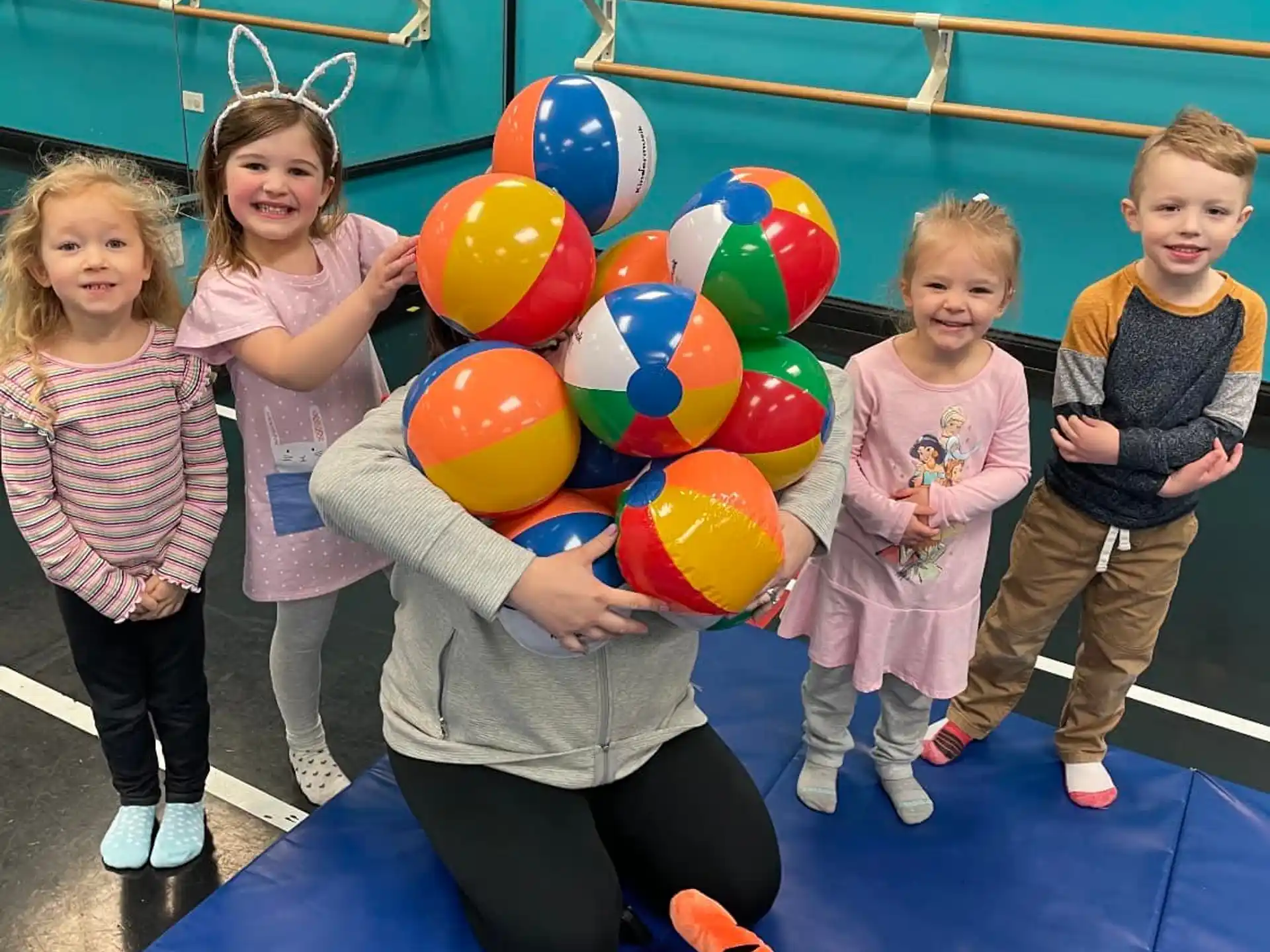 a person and several children holding balloons