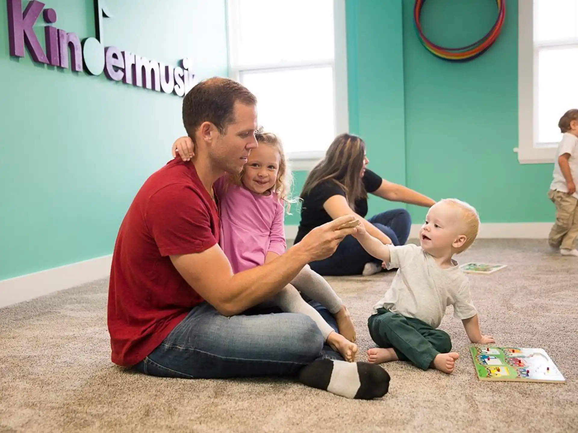 a man and woman with children playing with toys in a room