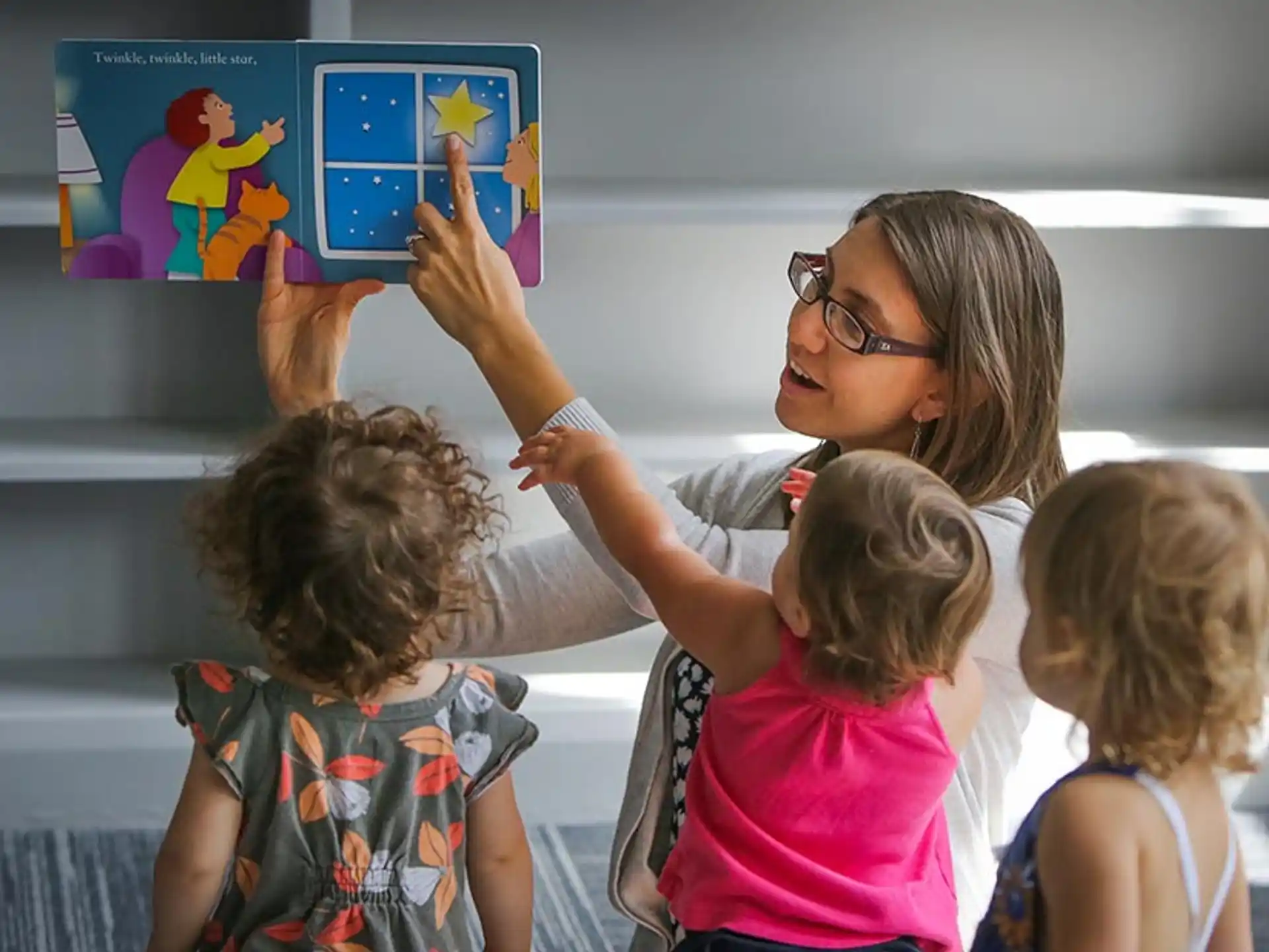 a person and children looking at a picture on a wall