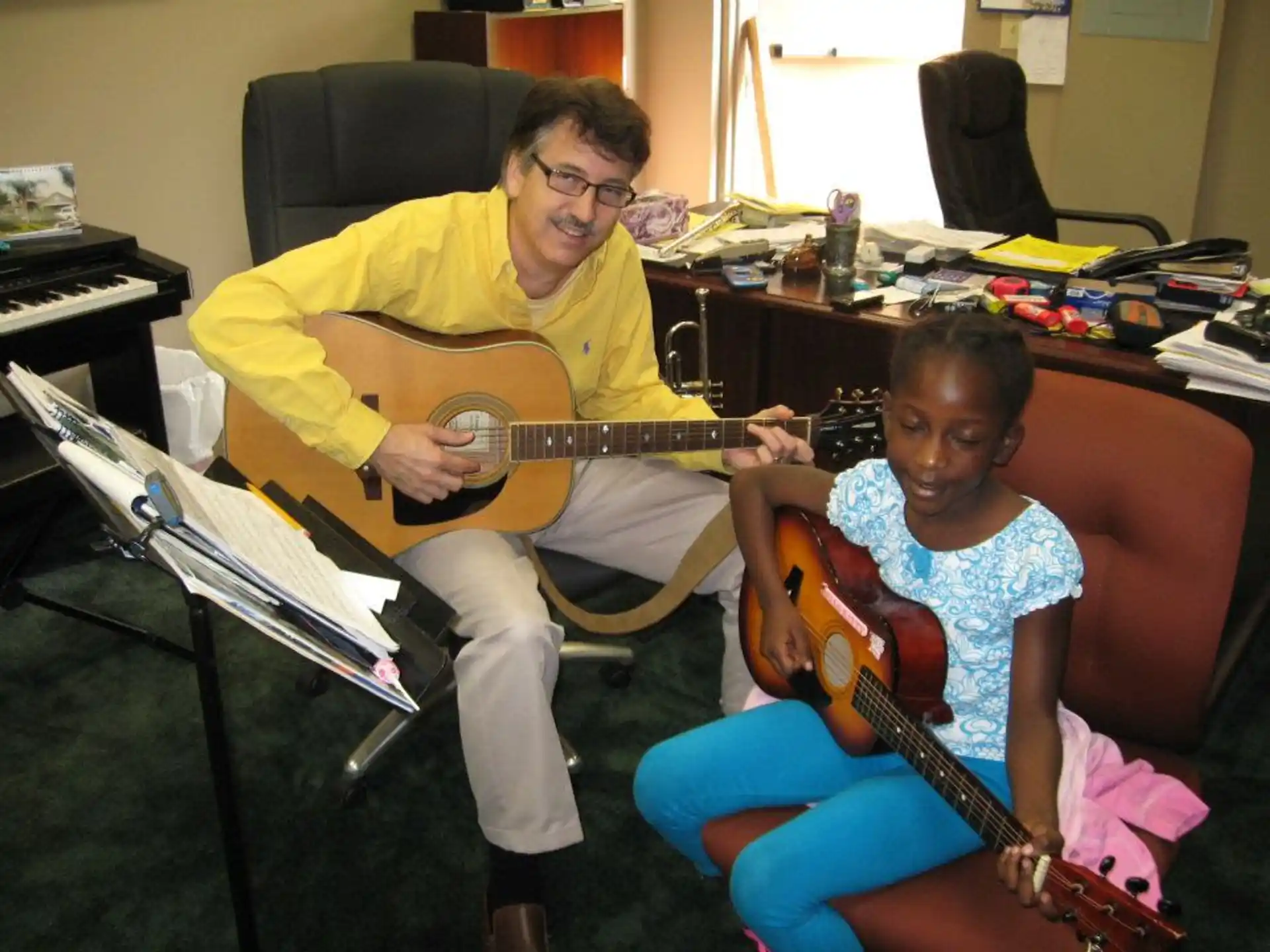 a person and a boy playing guitars