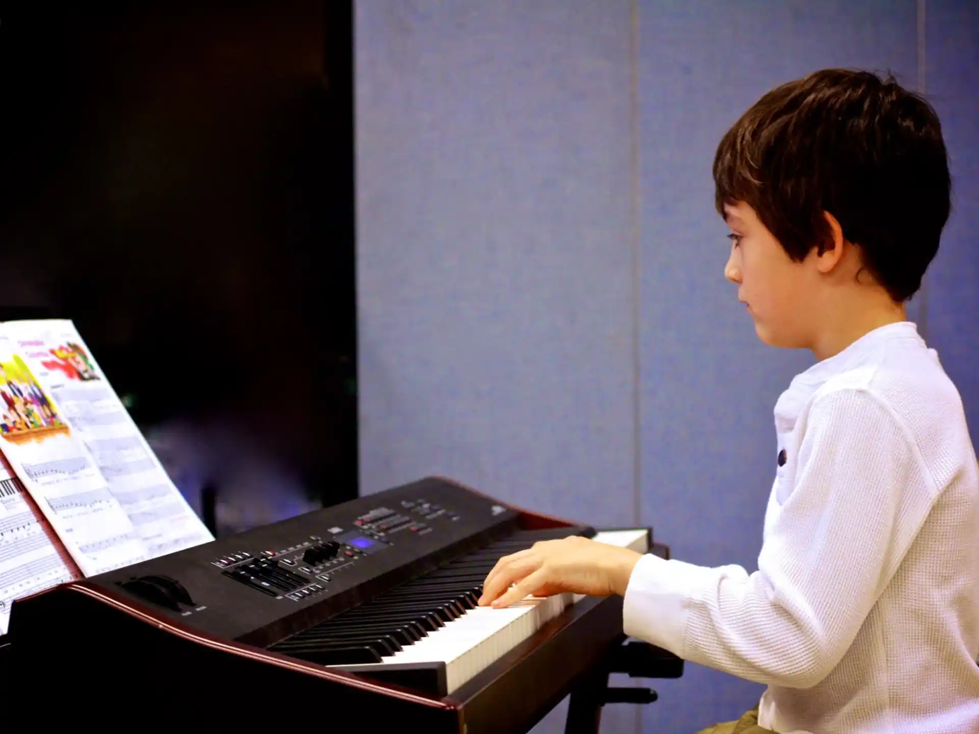 a young boy playing a piano