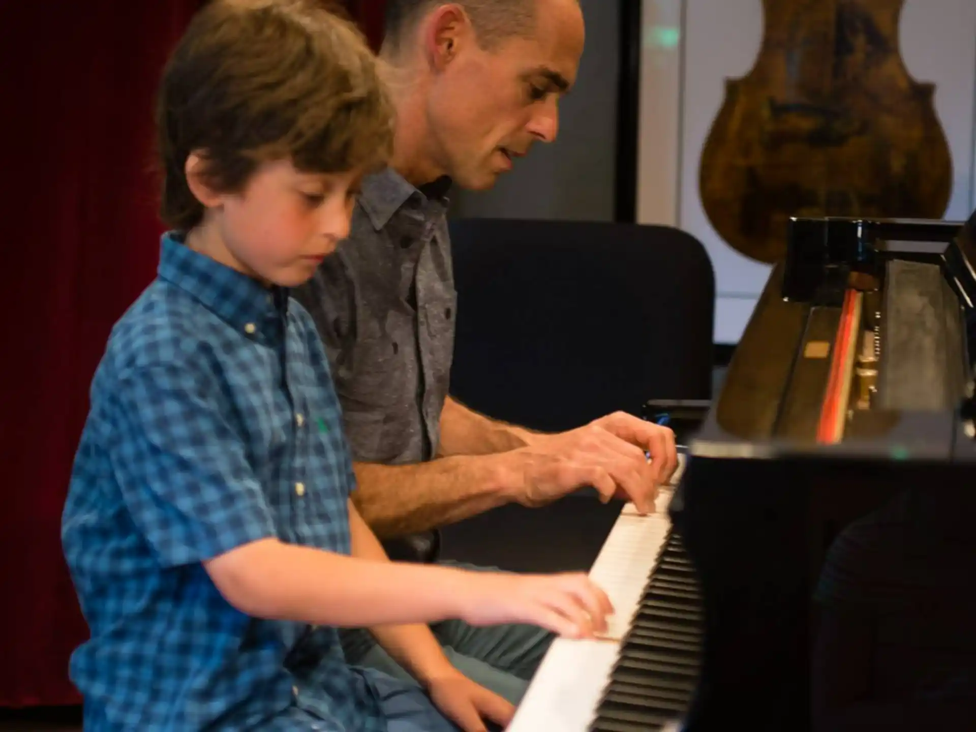 a man and a boy playing piano