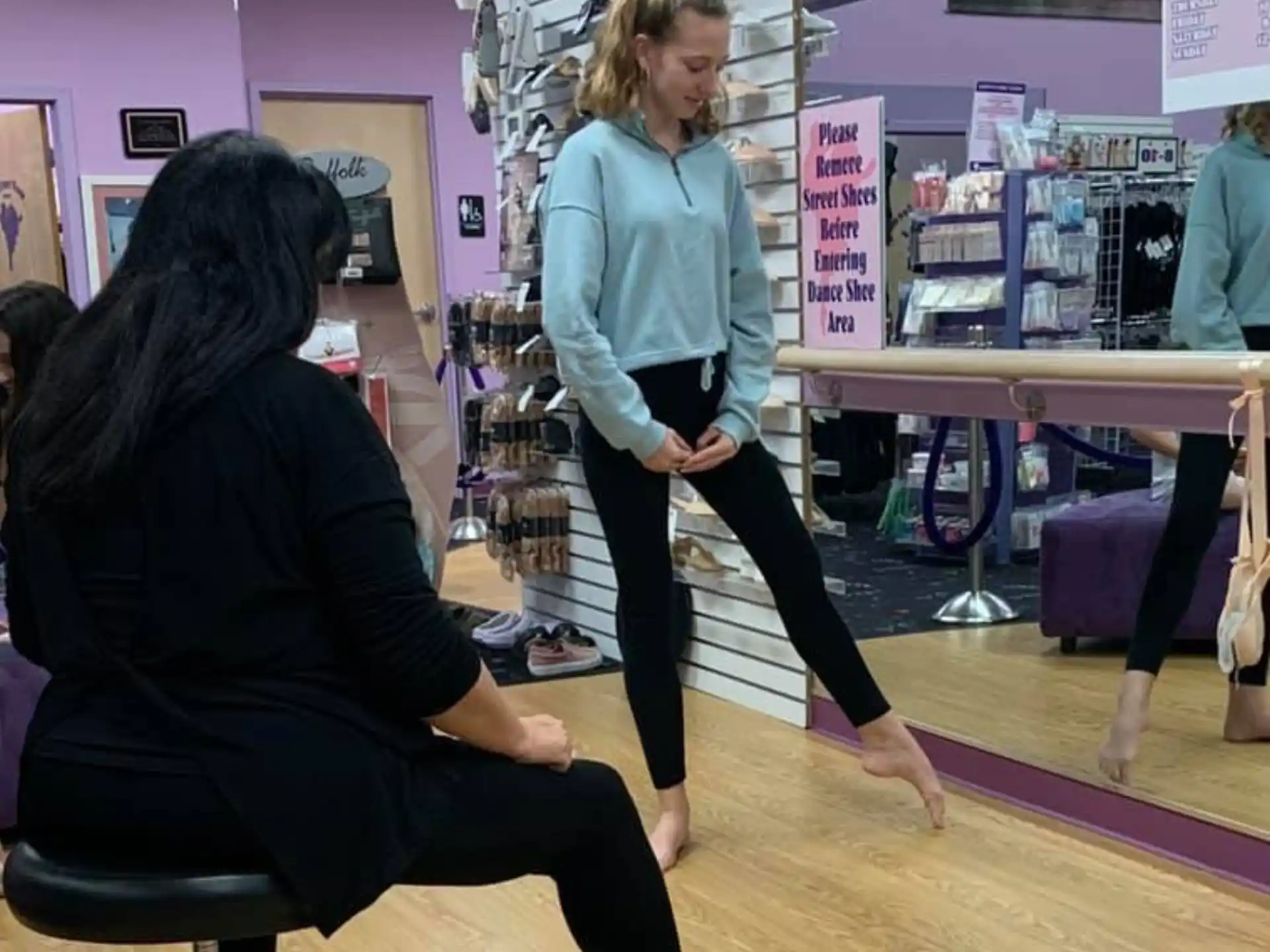 a person standing next to a person sitting in a chair