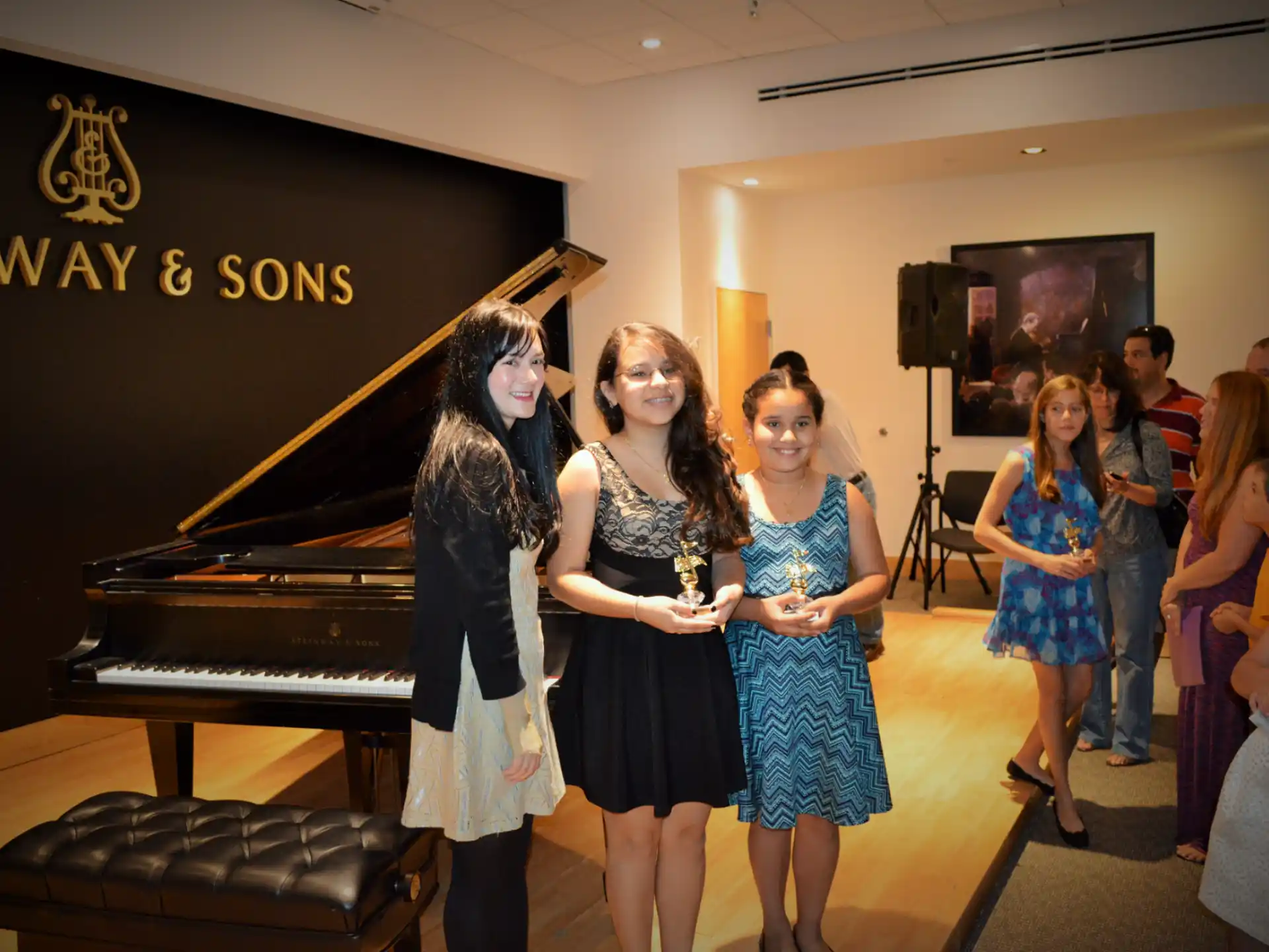 a group of girls standing in front of a piano