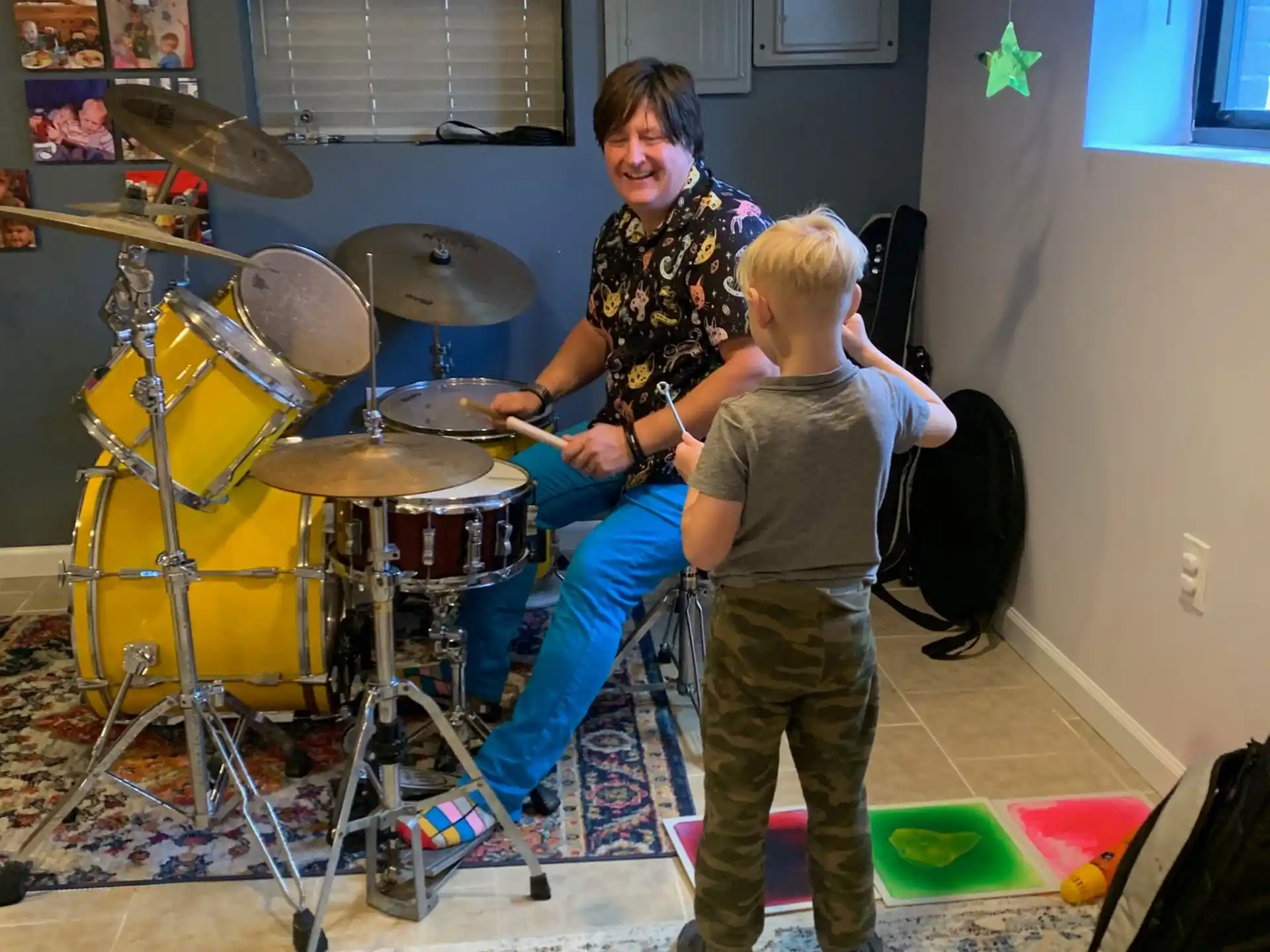 a person and a boy playing drums