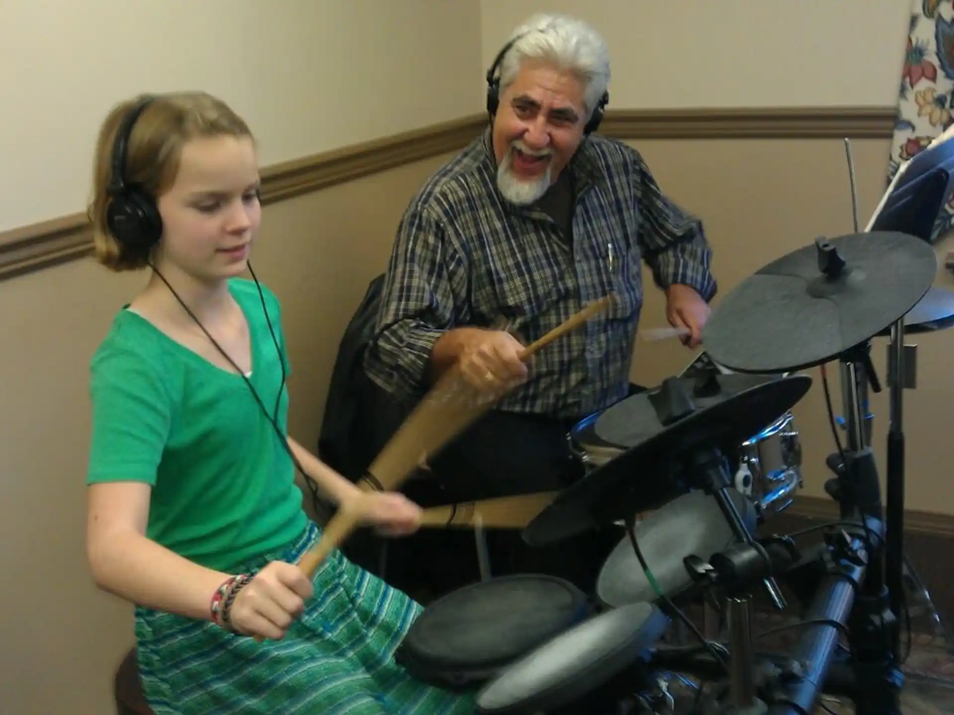 a woman playing the drums with a man and a woman