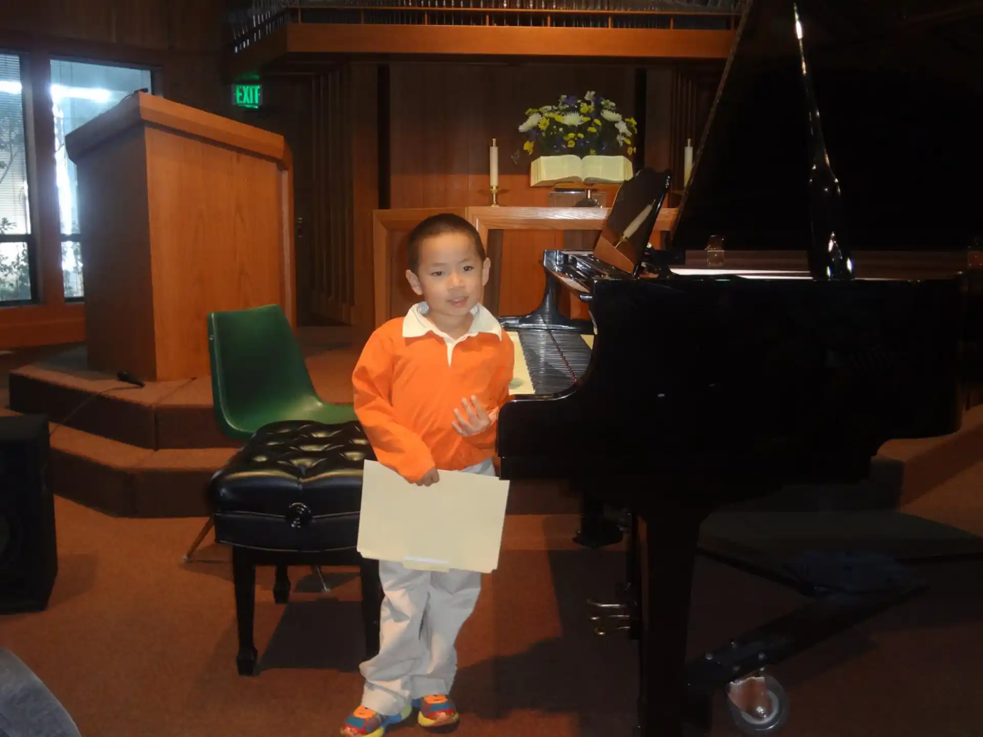 a boy standing in front of a piano