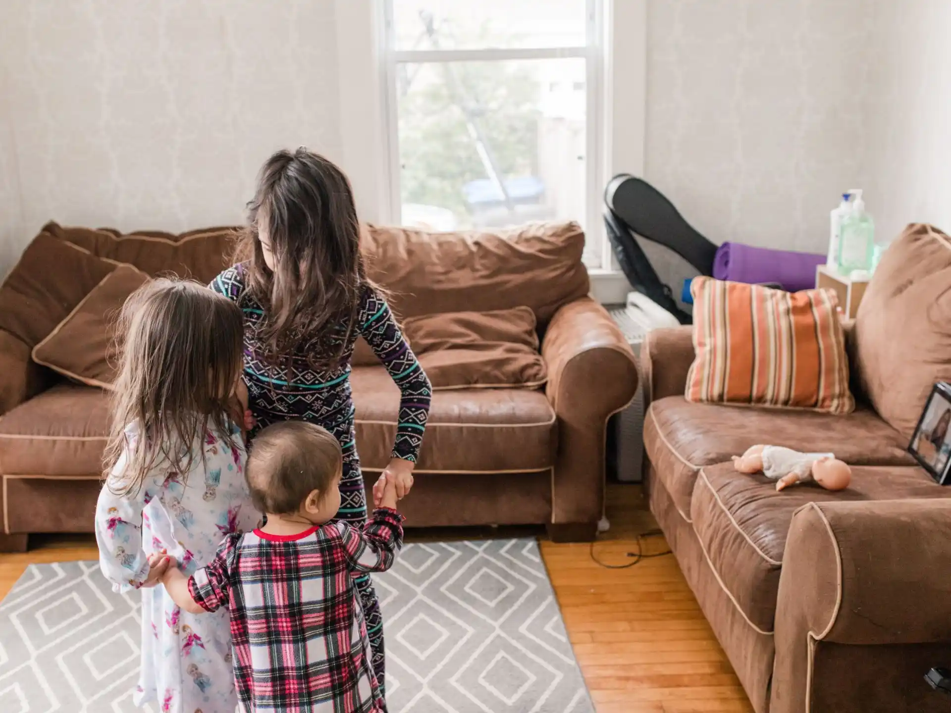 a person and two children playing in a living room
