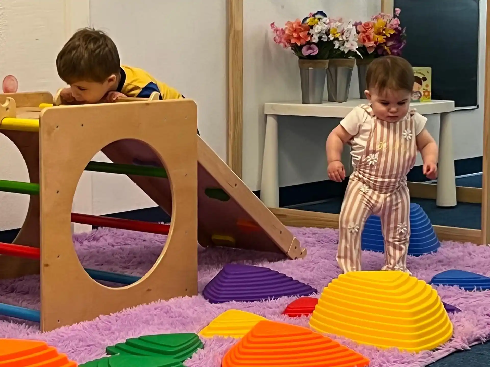 a couple of kids playing with colorful paper on a table