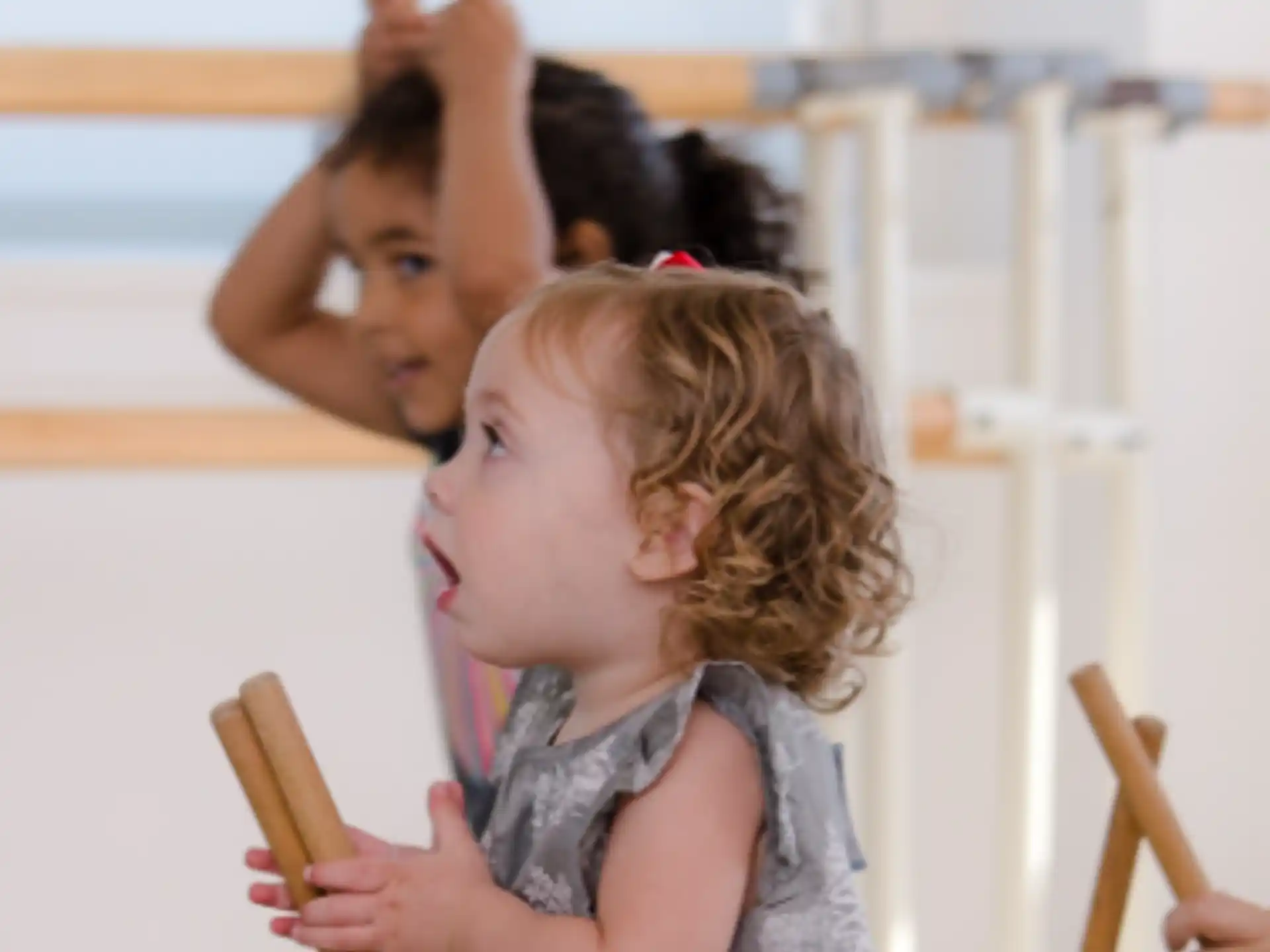 a person and a child playing with wooden sticks