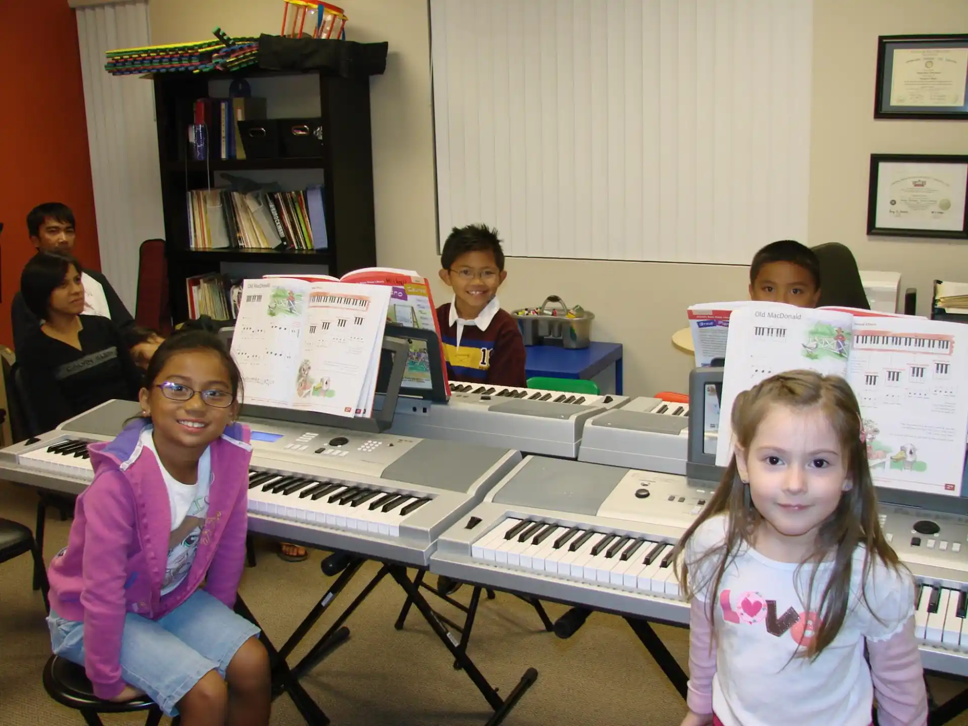 a group of kids sitting at a piano