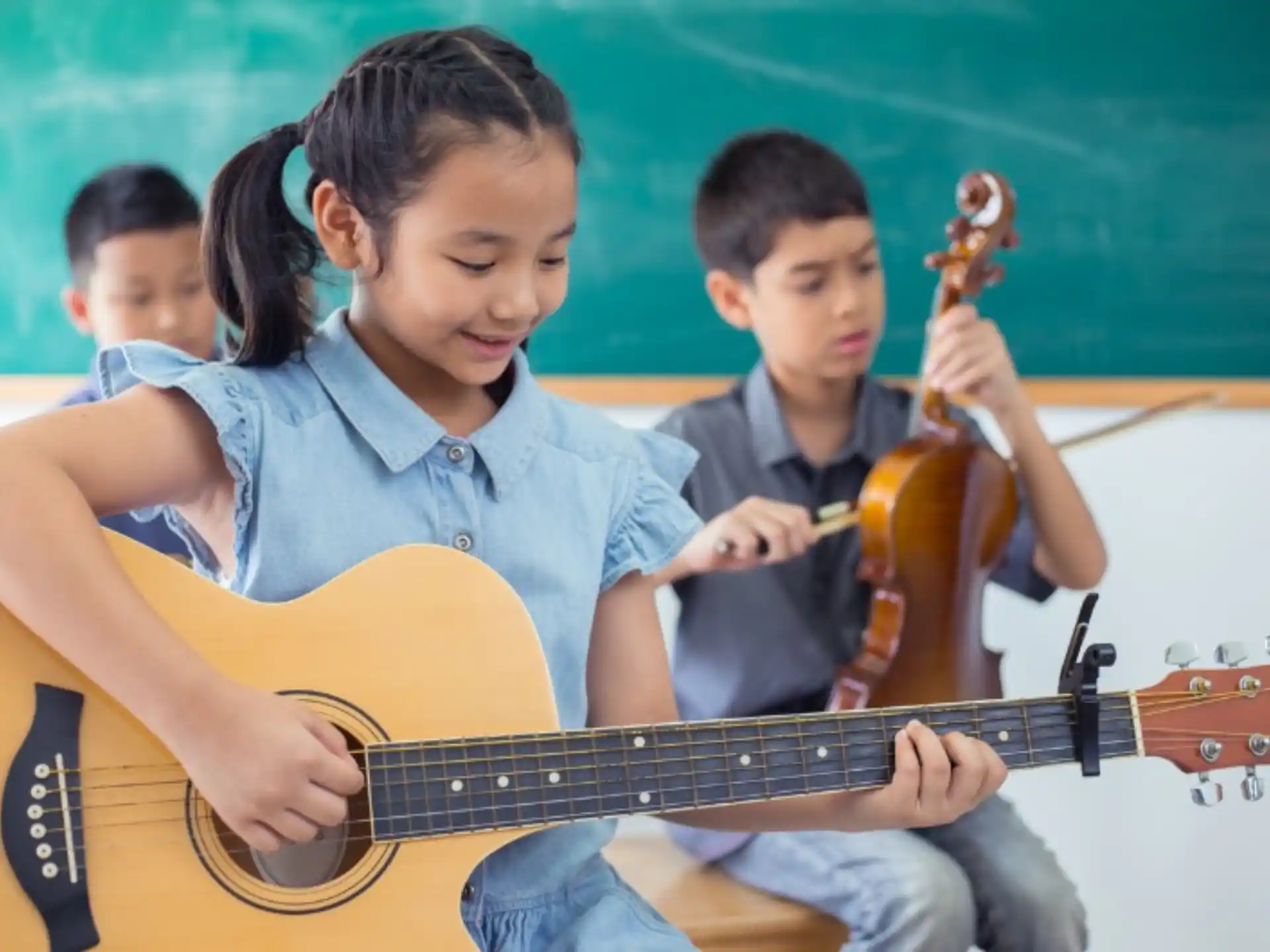a few children playing guitars