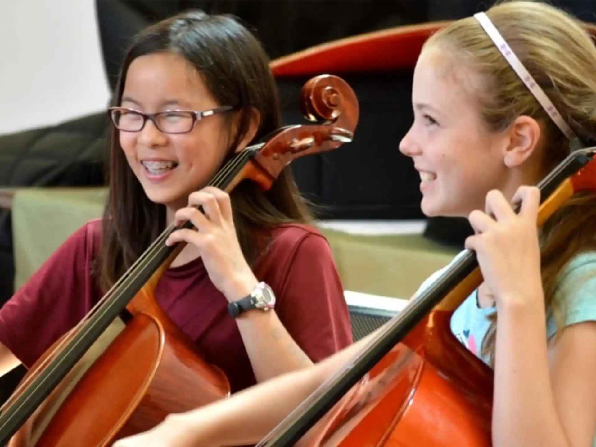 a woman playing a violin with a young girl