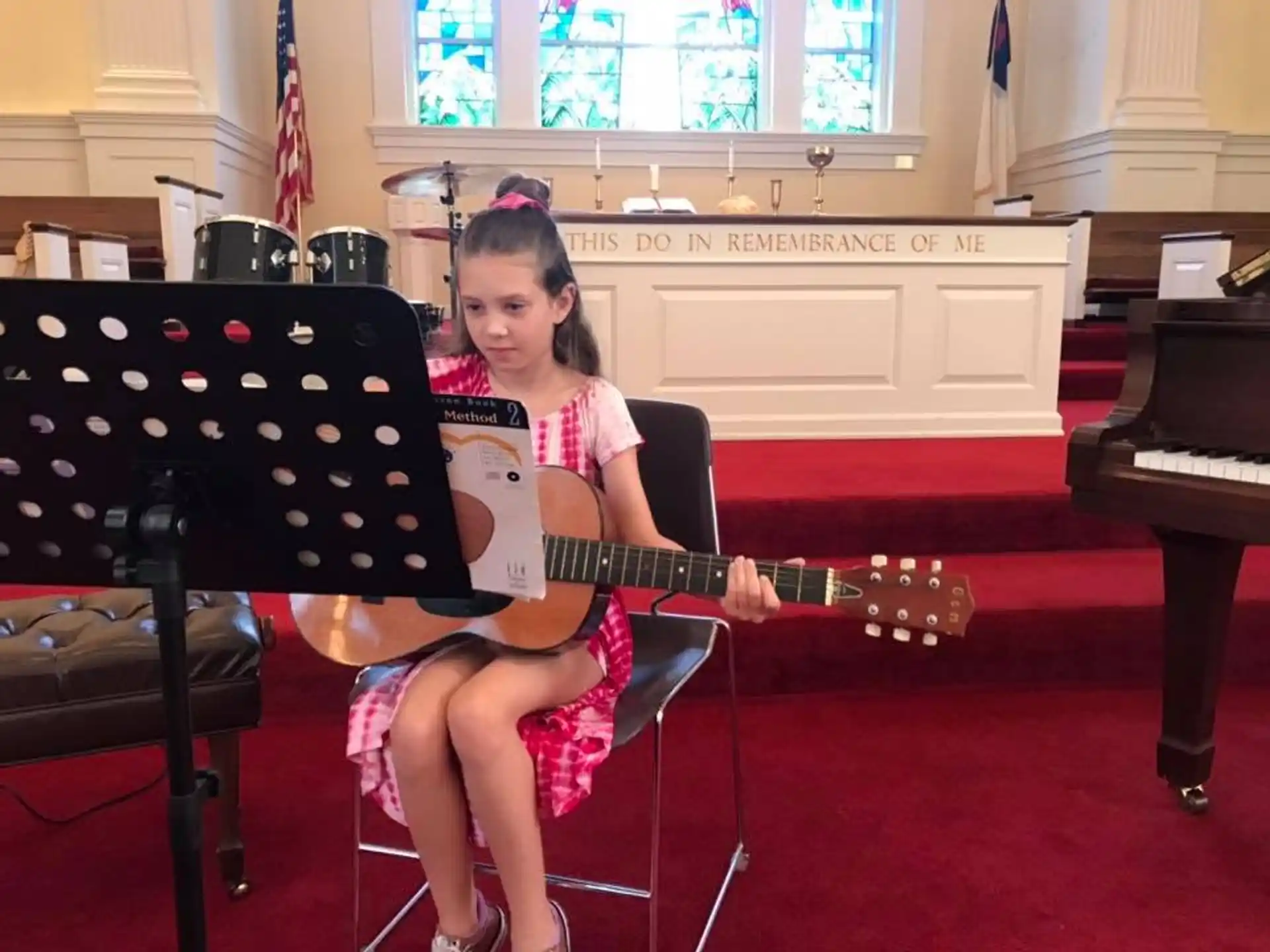 a girl sitting in a chair playing a guitar