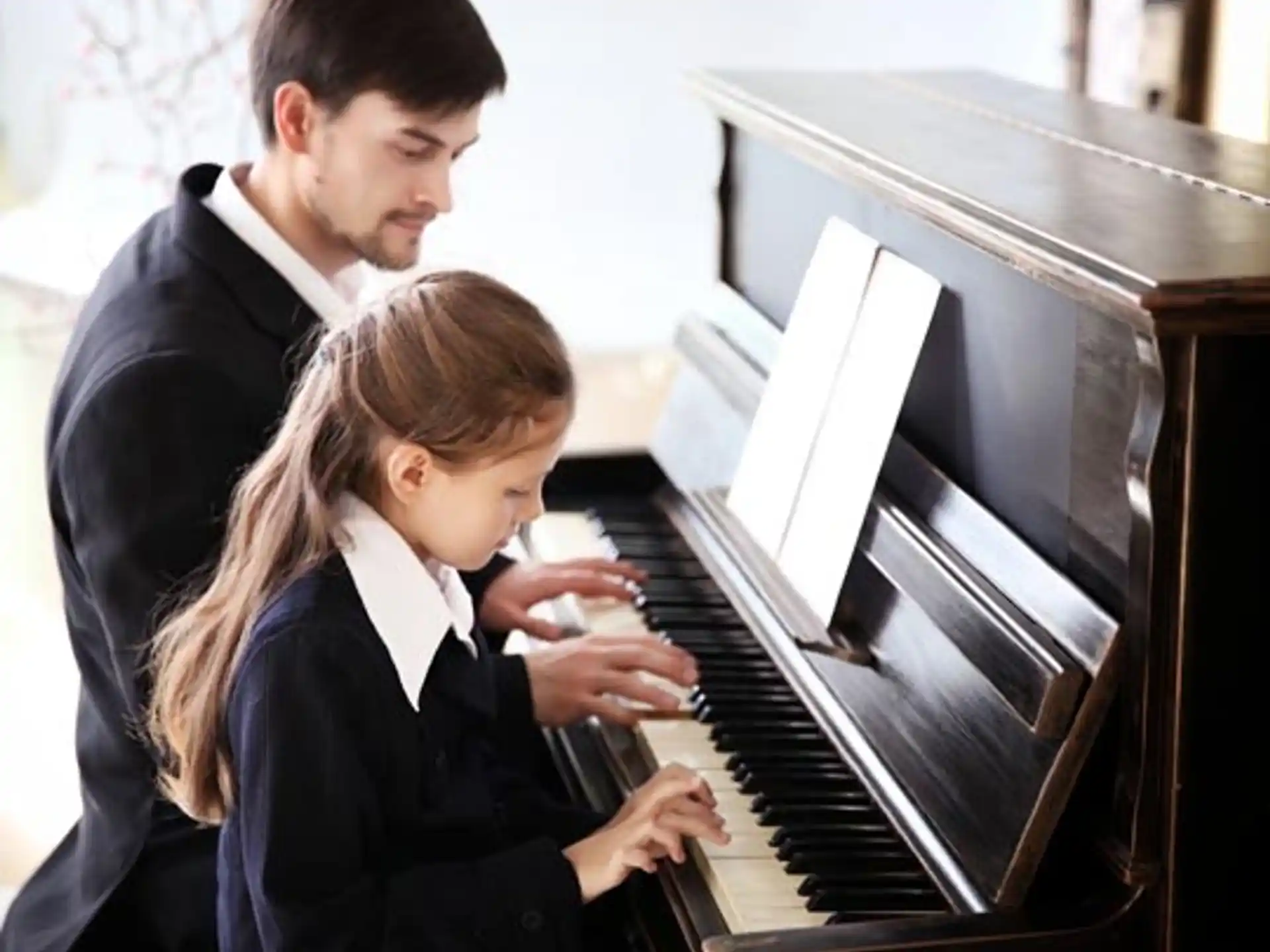 a man and a woman playing a piano
