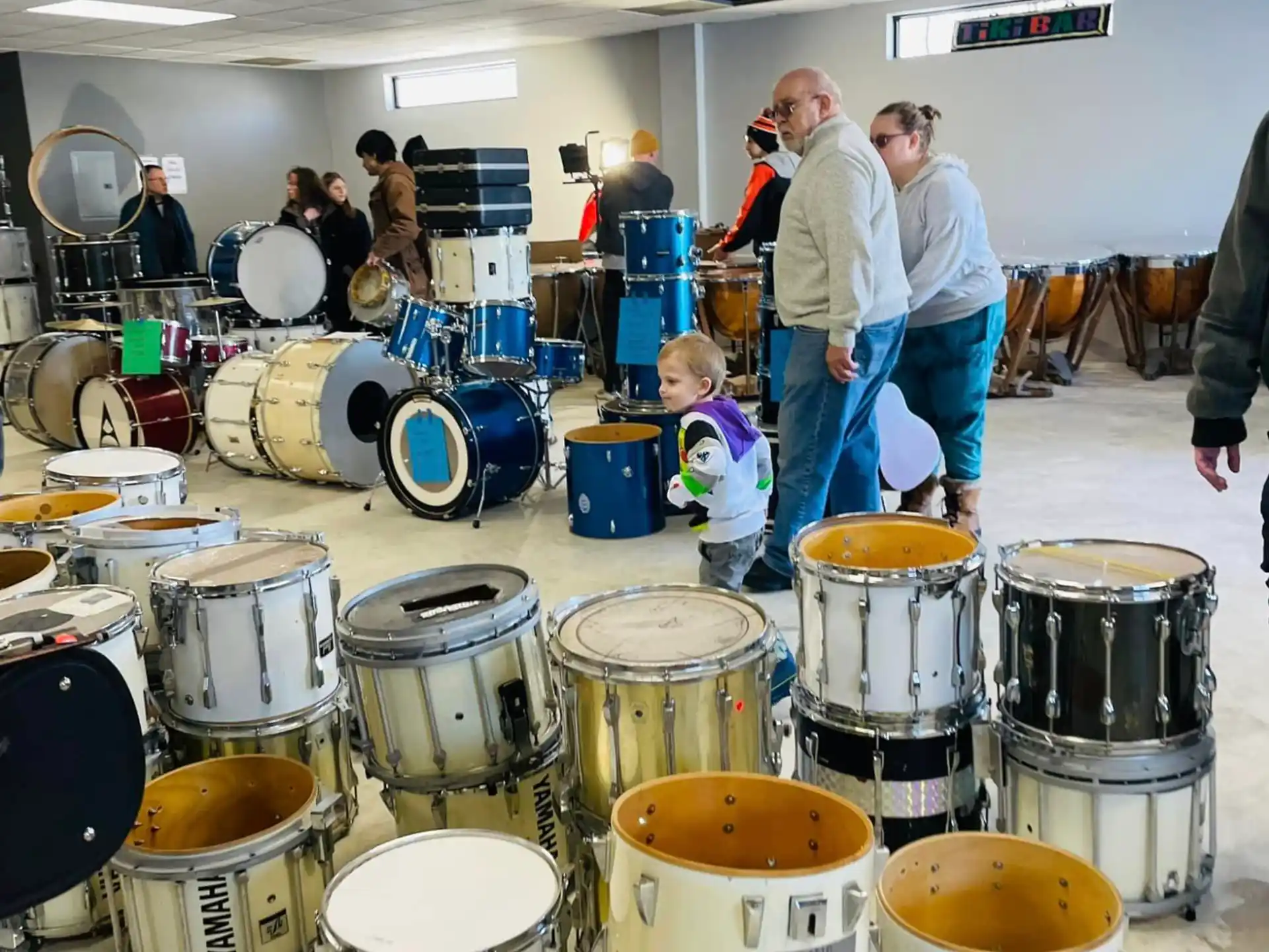 a group of people standing around a table with drums
