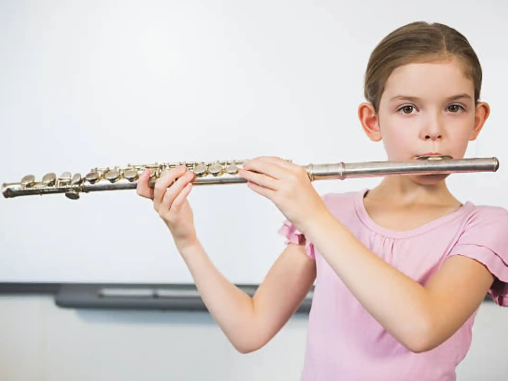 a young girl playing a flute