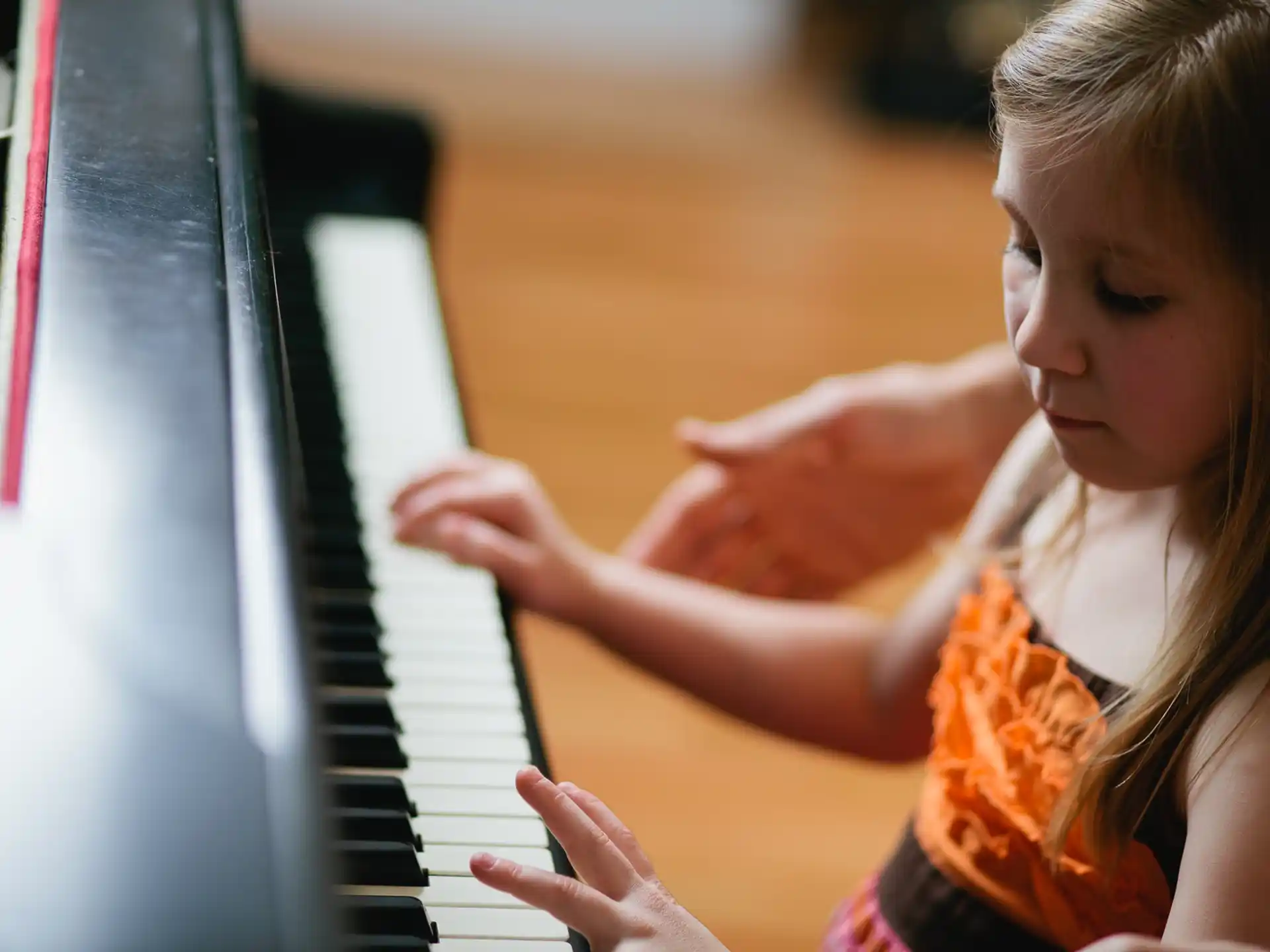 a young girl playing a piano