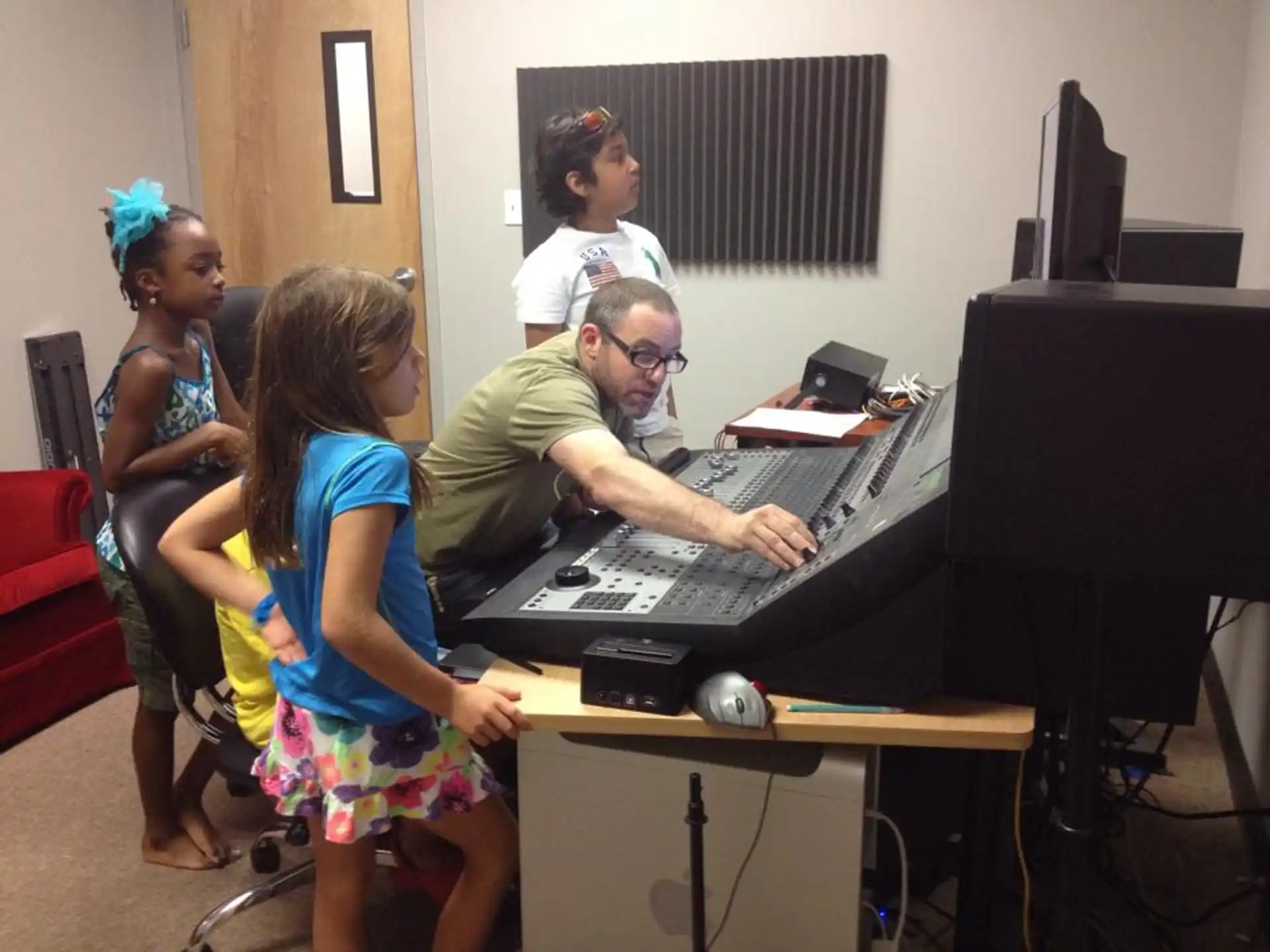a person and a couple of girls playing a piano