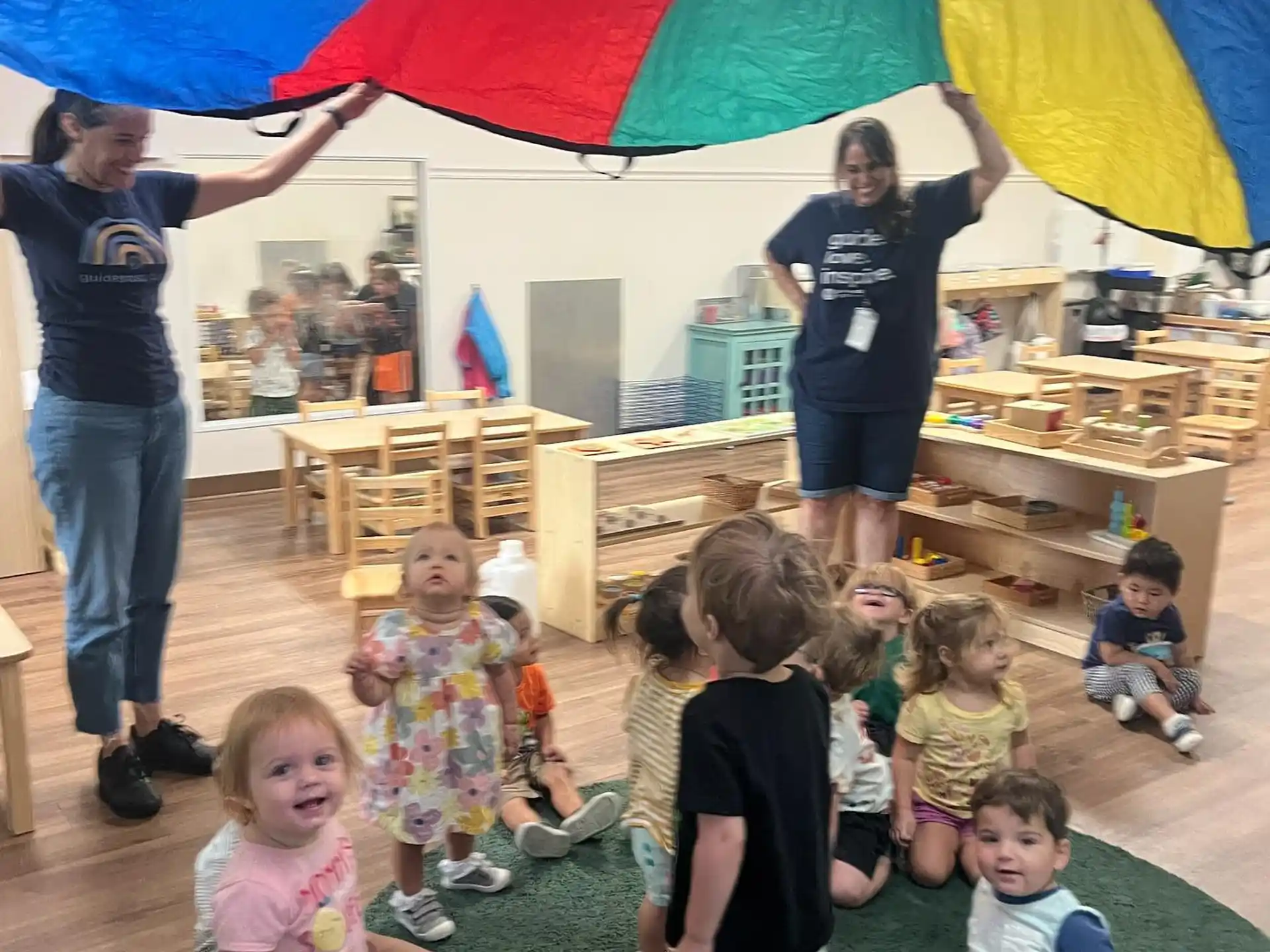 a group of children under a colorful umbrella