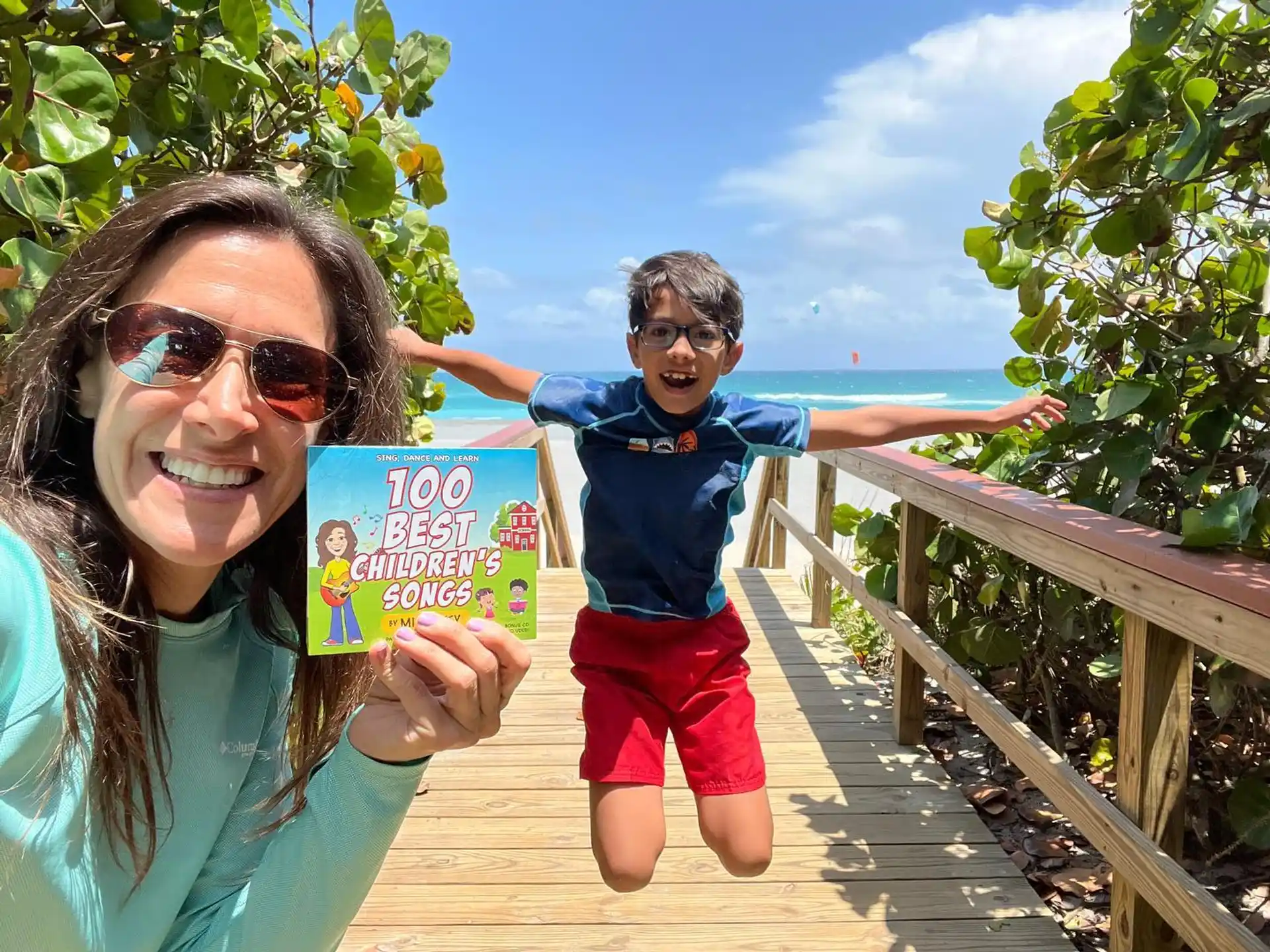 a woman and a boy holding a book and posing for the camera