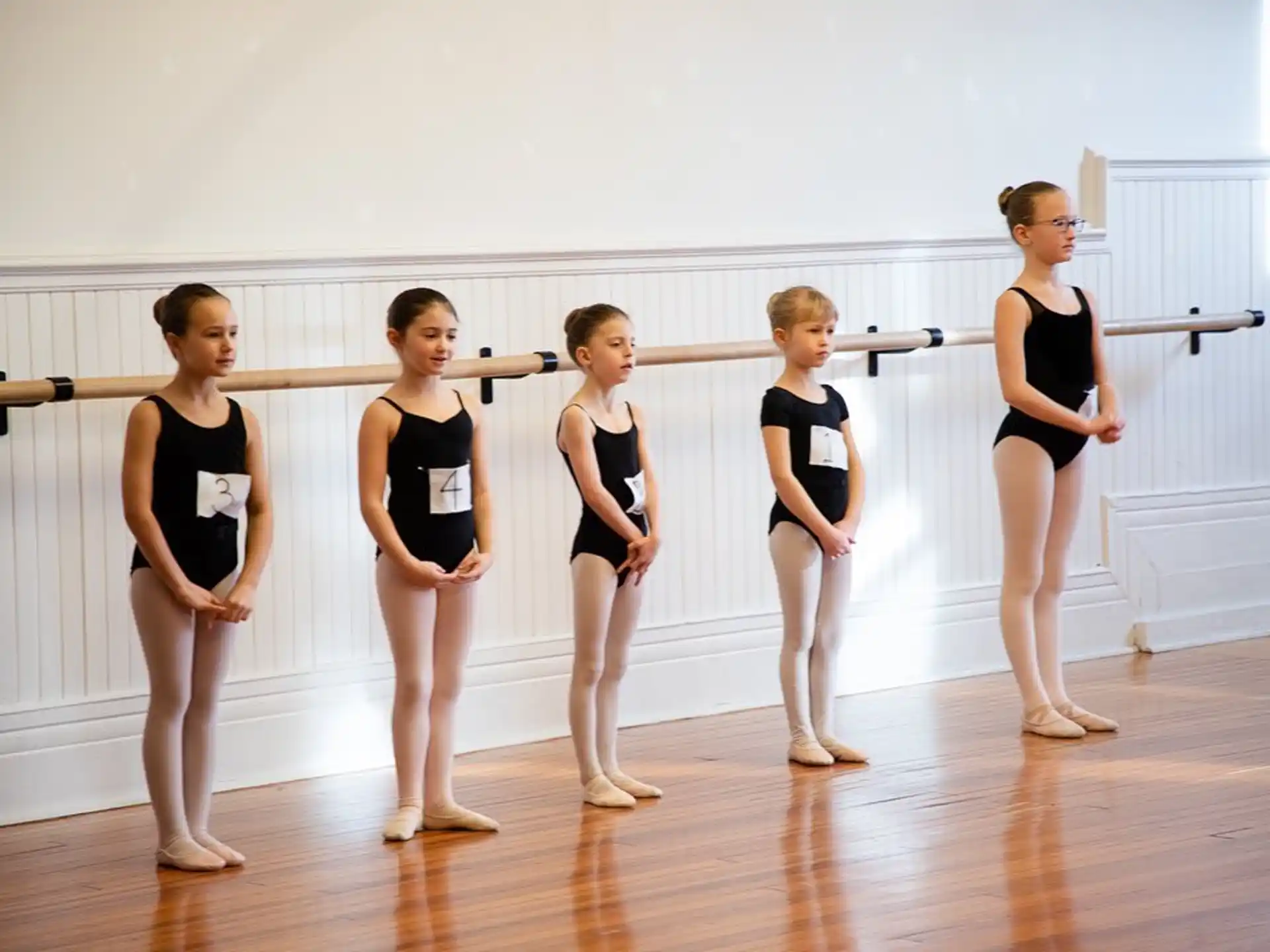 a group of women in leotards on a wood floor