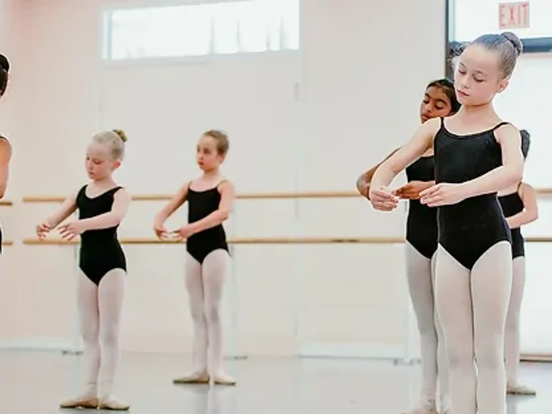 a group of women in black leotards in a room