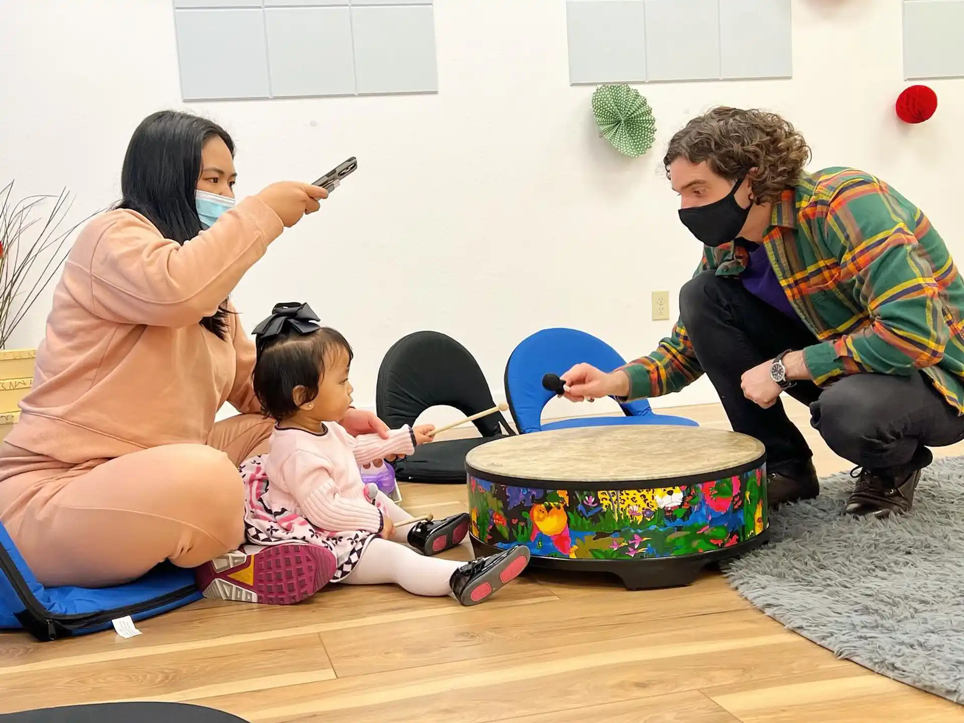 a group of people sitting on the floor with a child playing with a toy