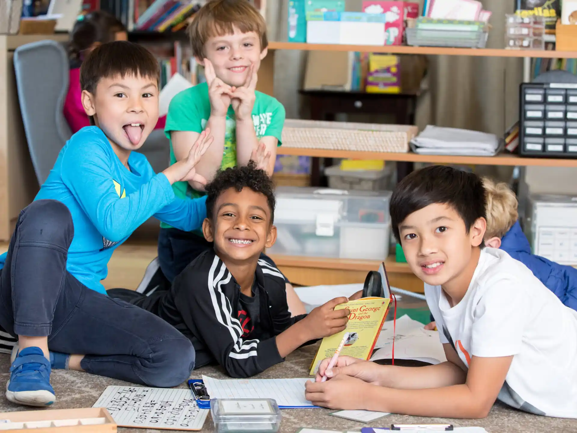 a group of boys sitting on the floor and smiling