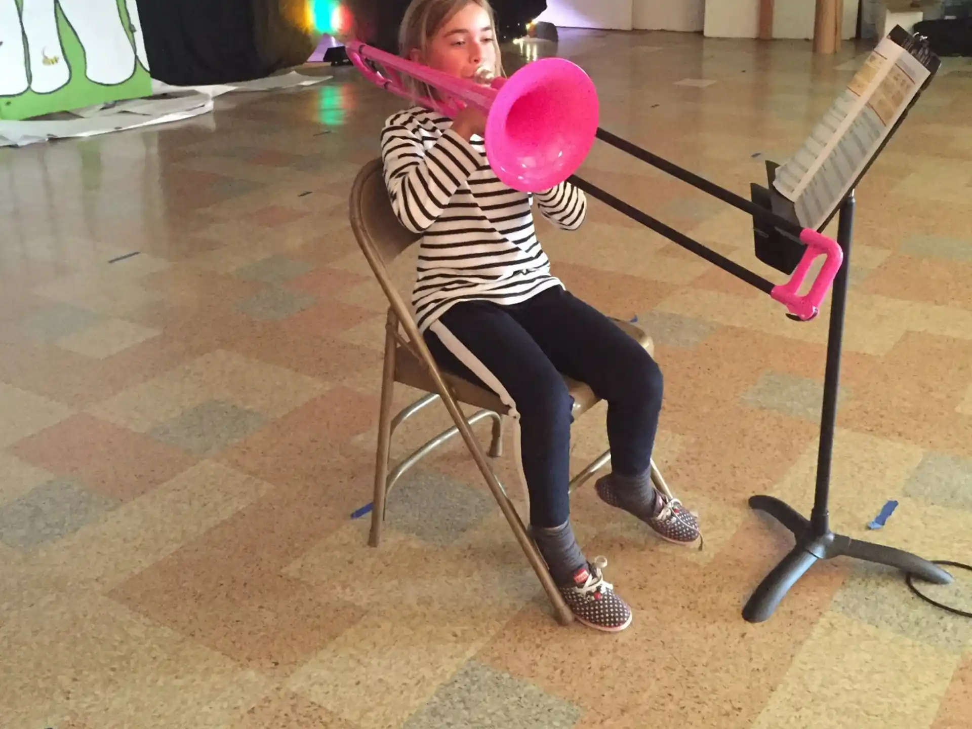 a person sitting in a chair holding a pink balloon