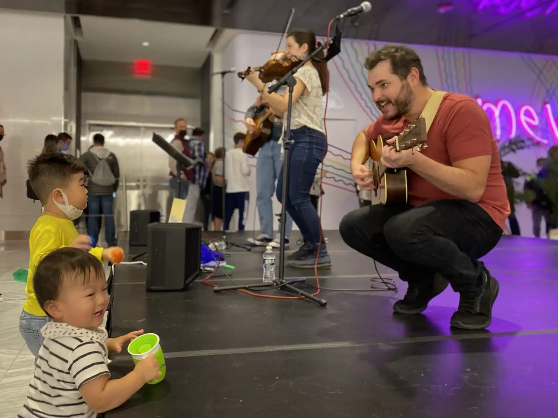 a person playing guitar with kids