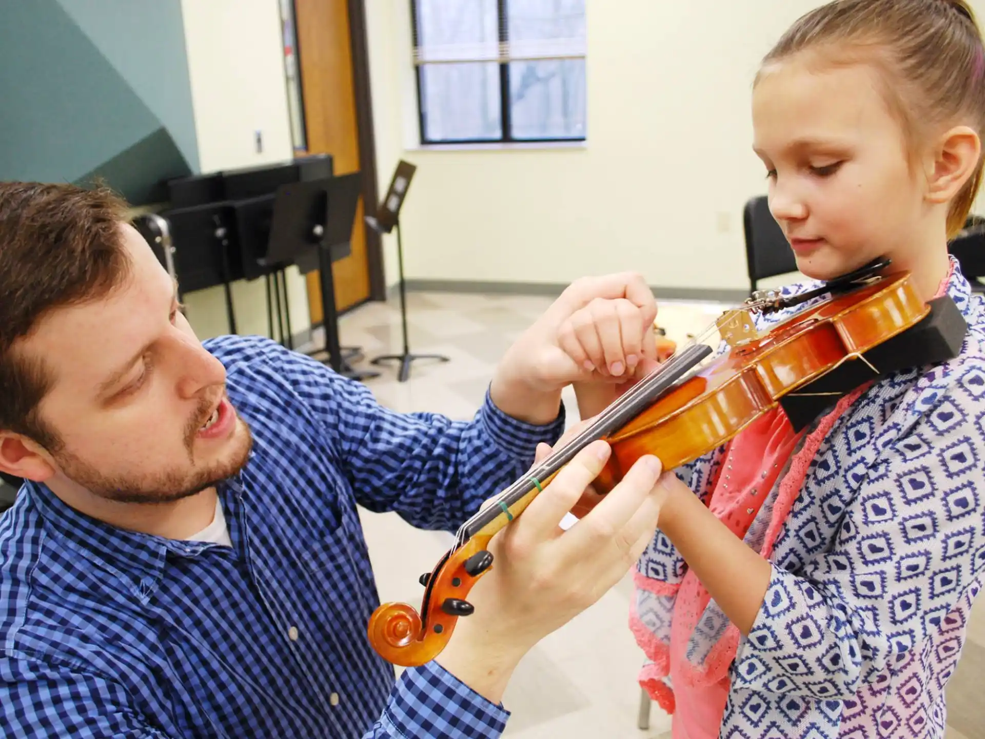 a person playing a violin to a young boy