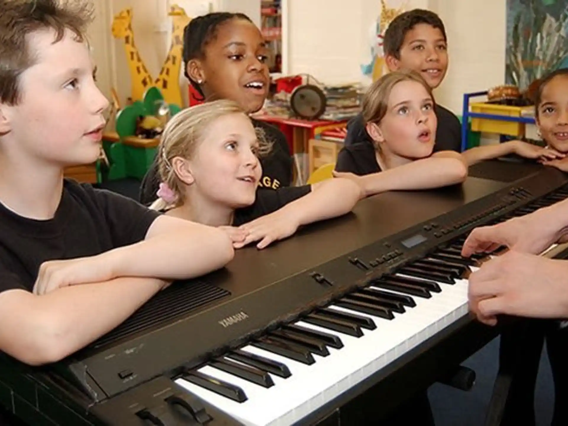 a group of children playing a piano