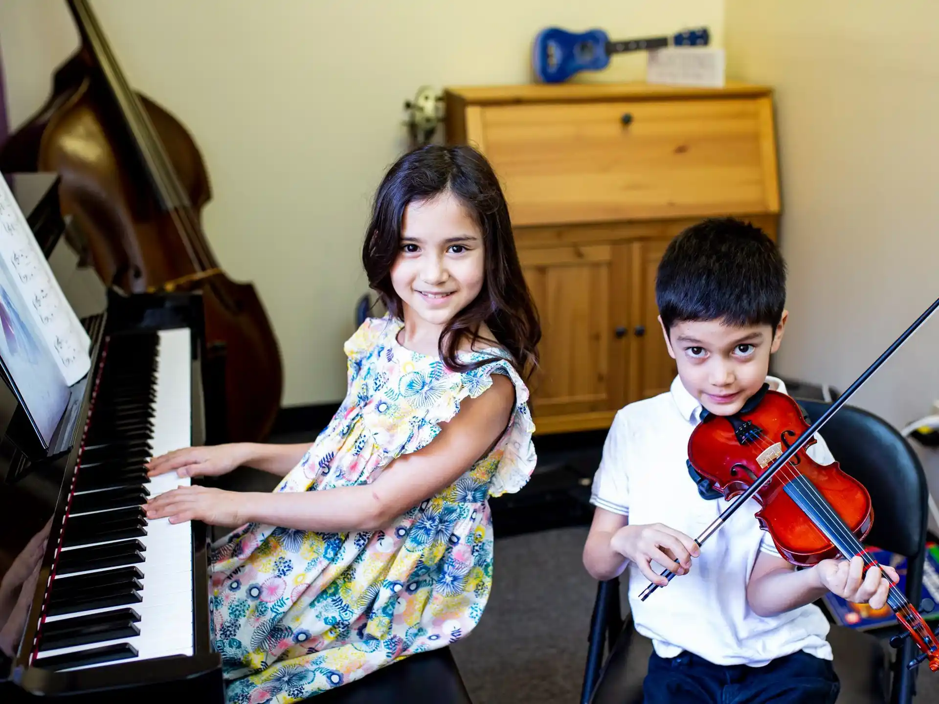 a person and a boy playing the piano
