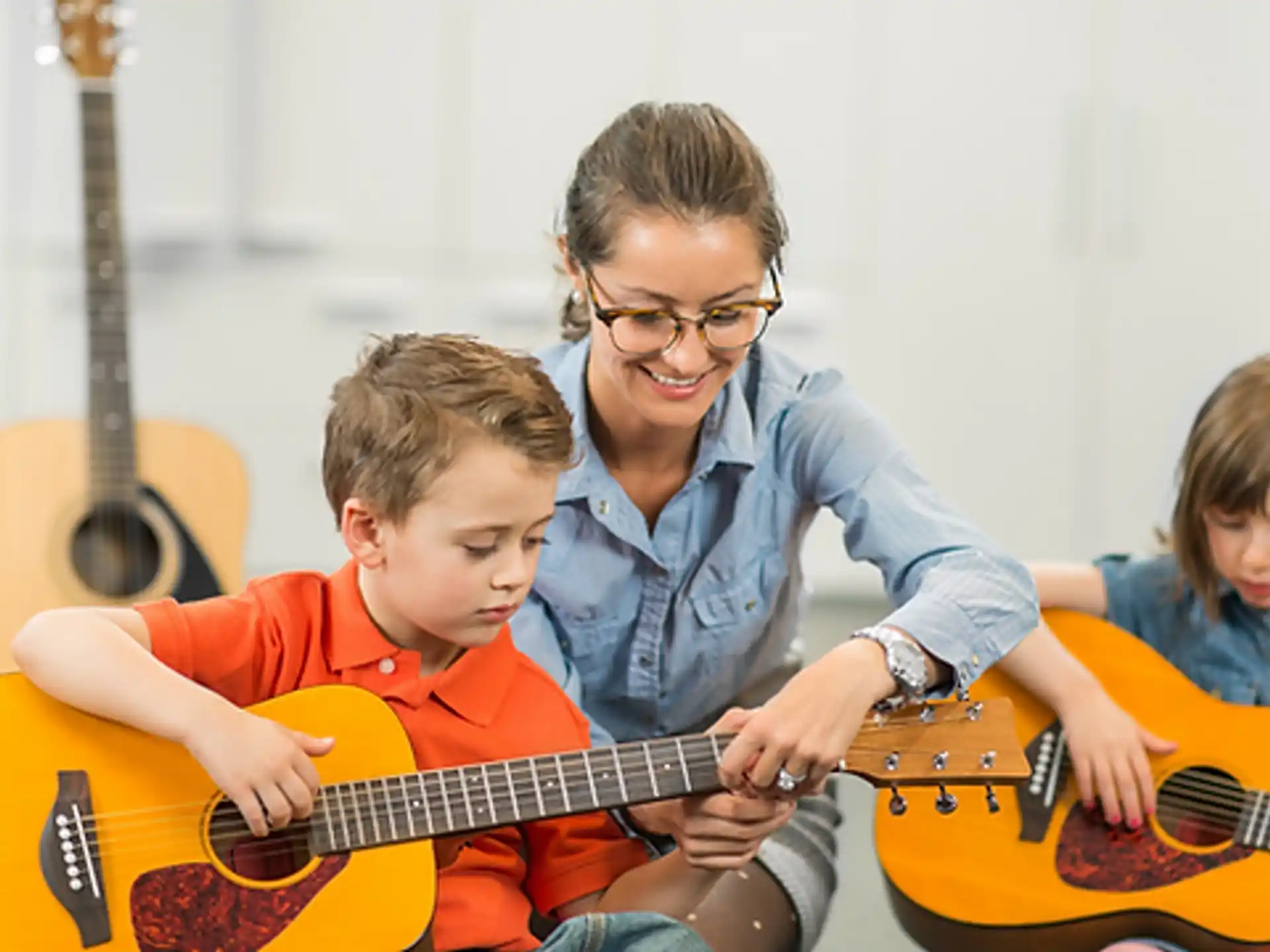 a person playing a guitar with kids