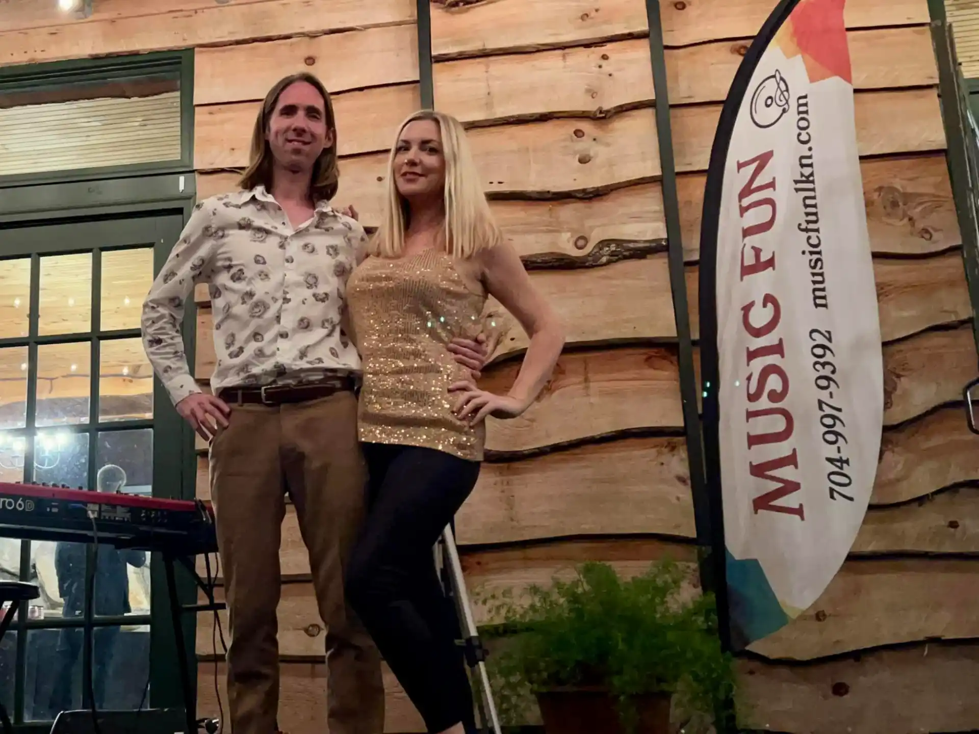 two women standing next to a surfboard