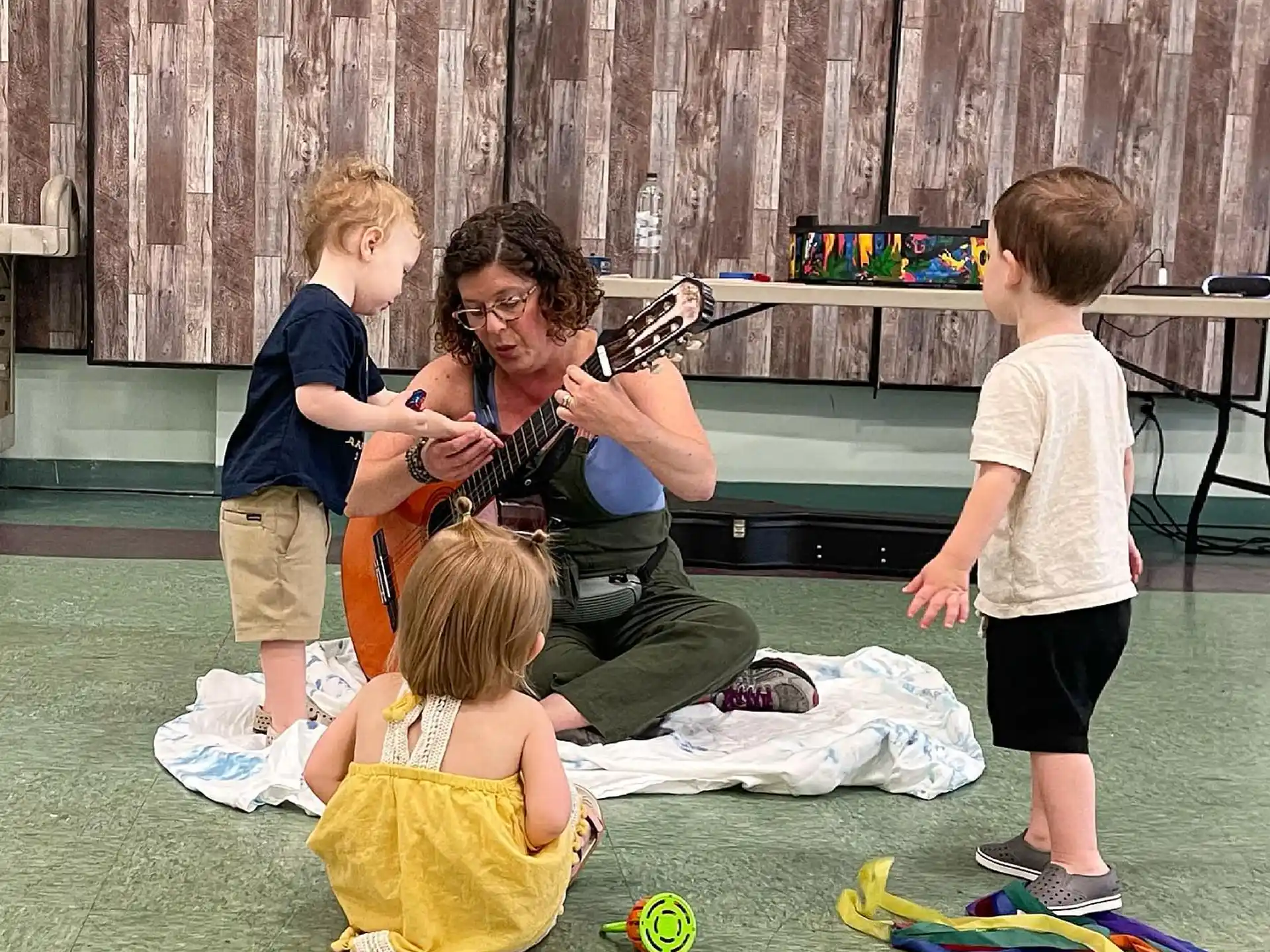 a person playing a guitar with children