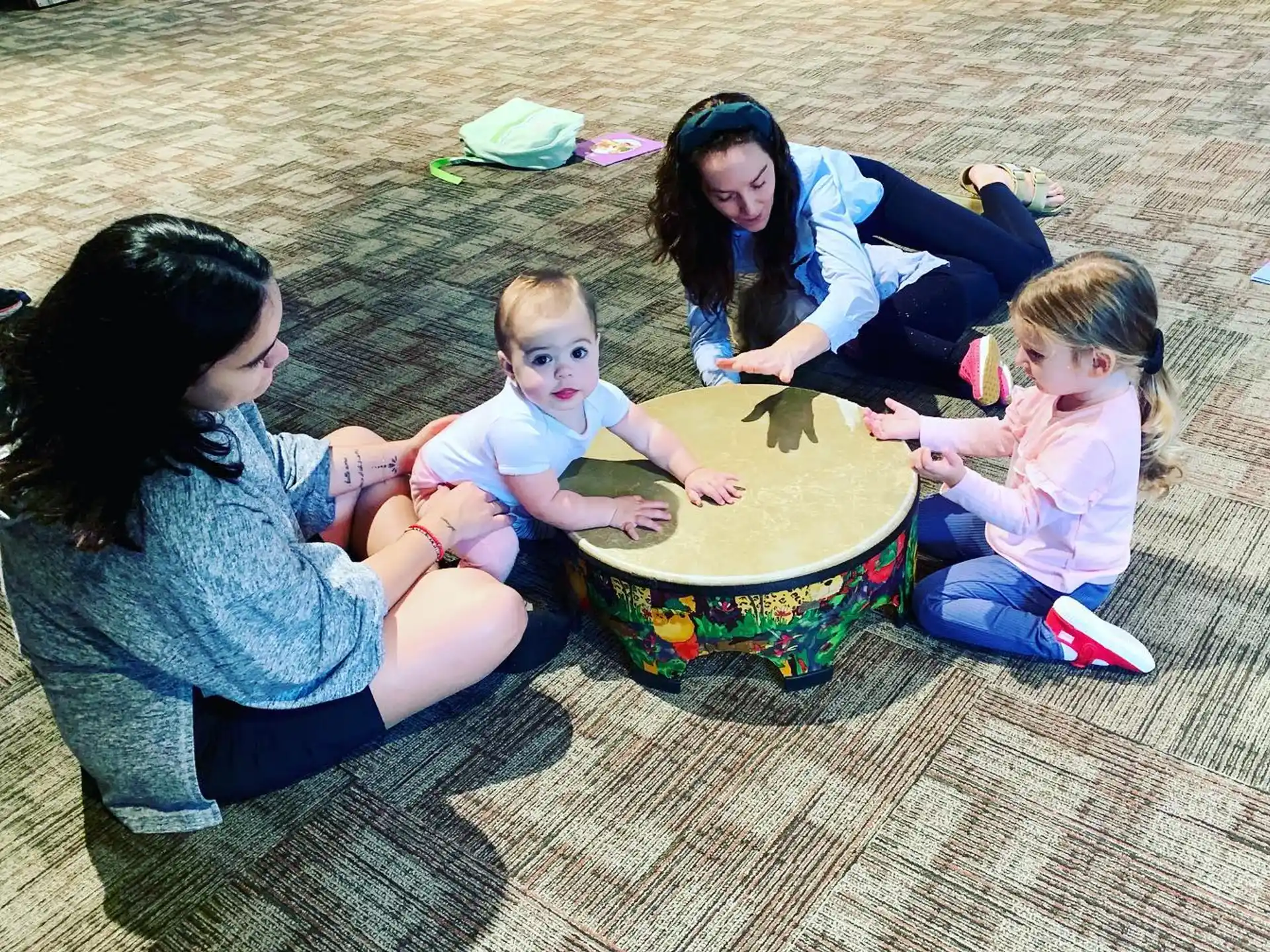 a group of people sitting on the ground looking at a globe