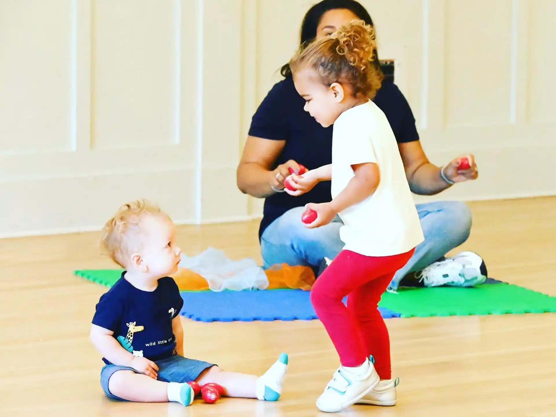 a person and two children playing on the floor