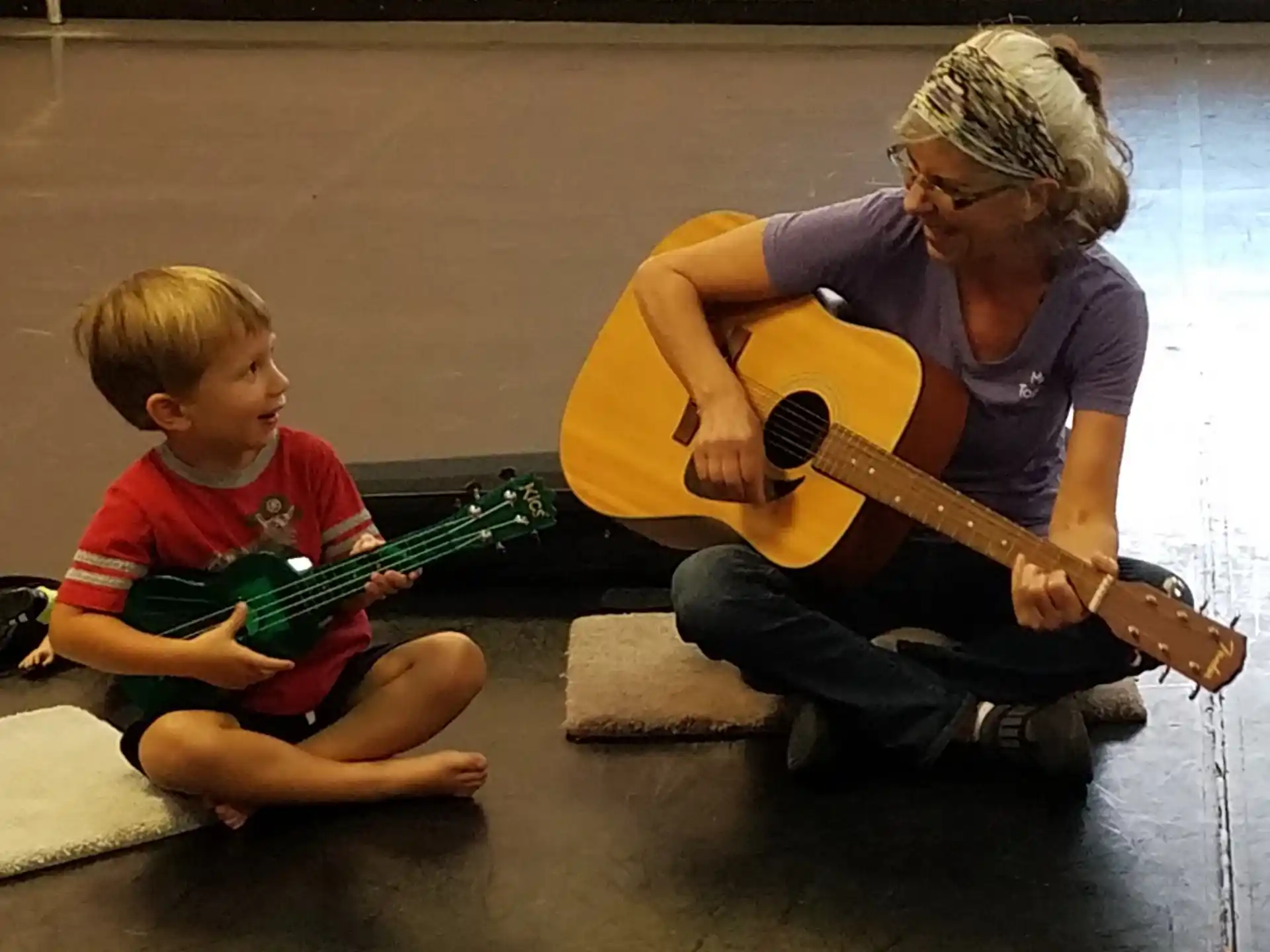 a person and a child playing guitar