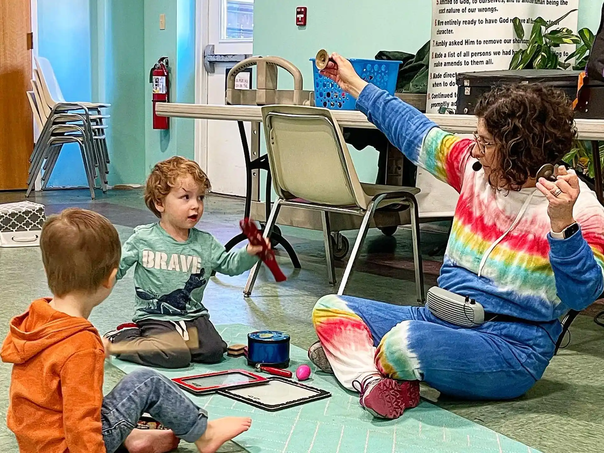 a person and two children playing with toys in a room