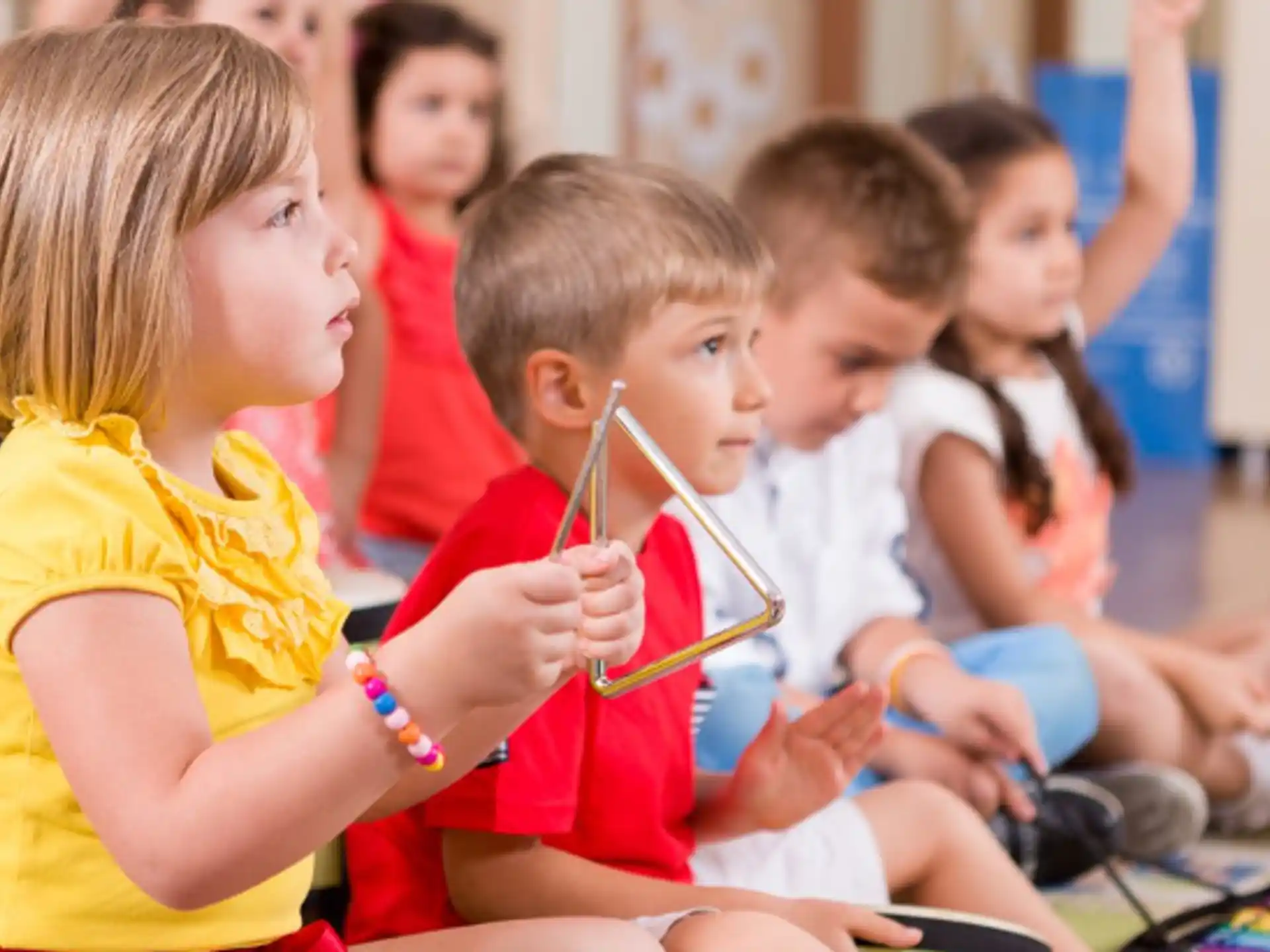 a group of children sitting in a circle with straws in their mouths