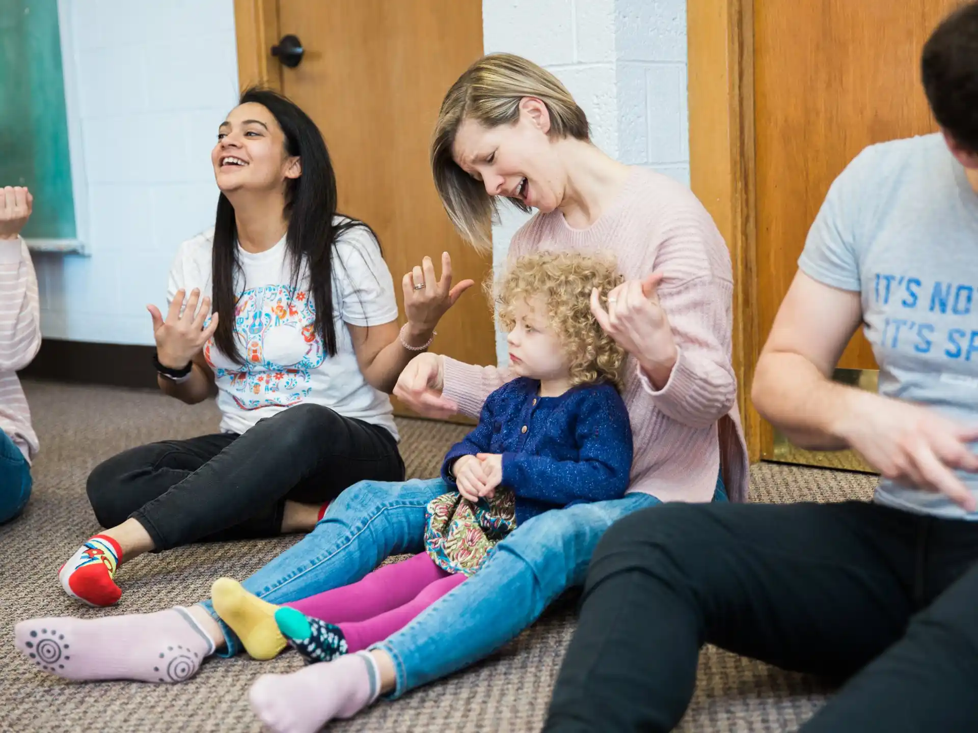 a group of people sitting on the floor and laughing