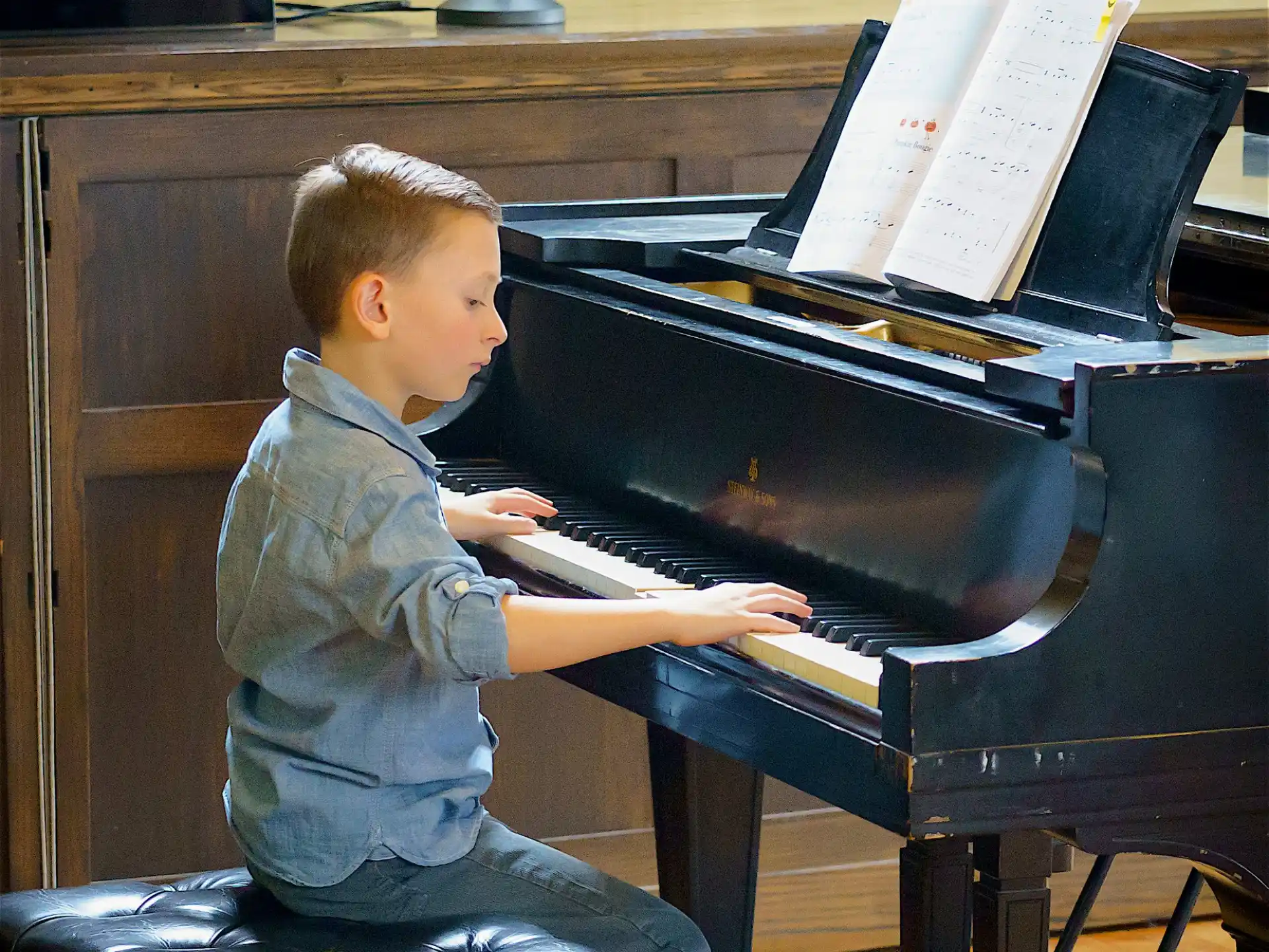a boy playing a piano