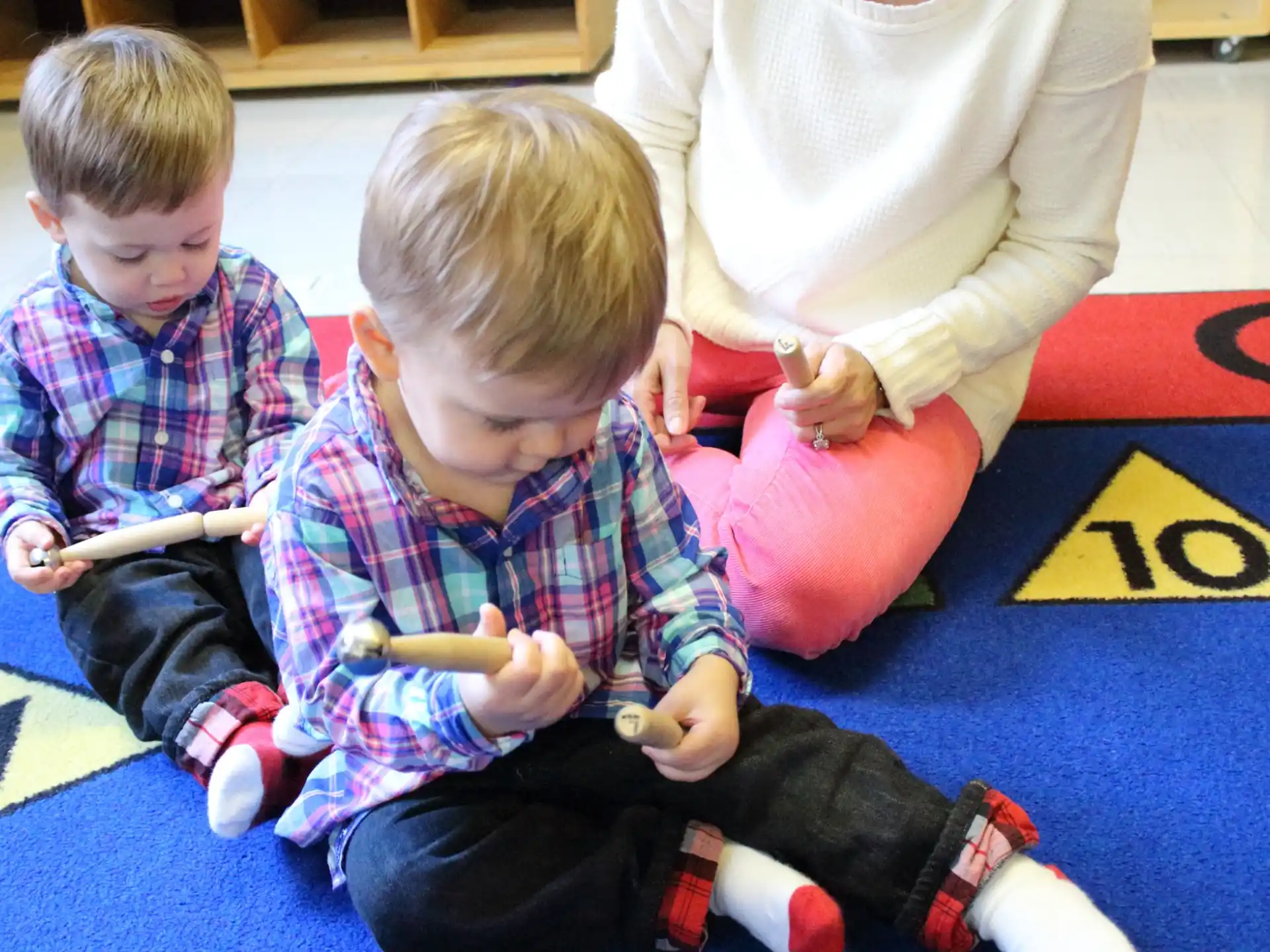 a person and two boys sitting on the floor