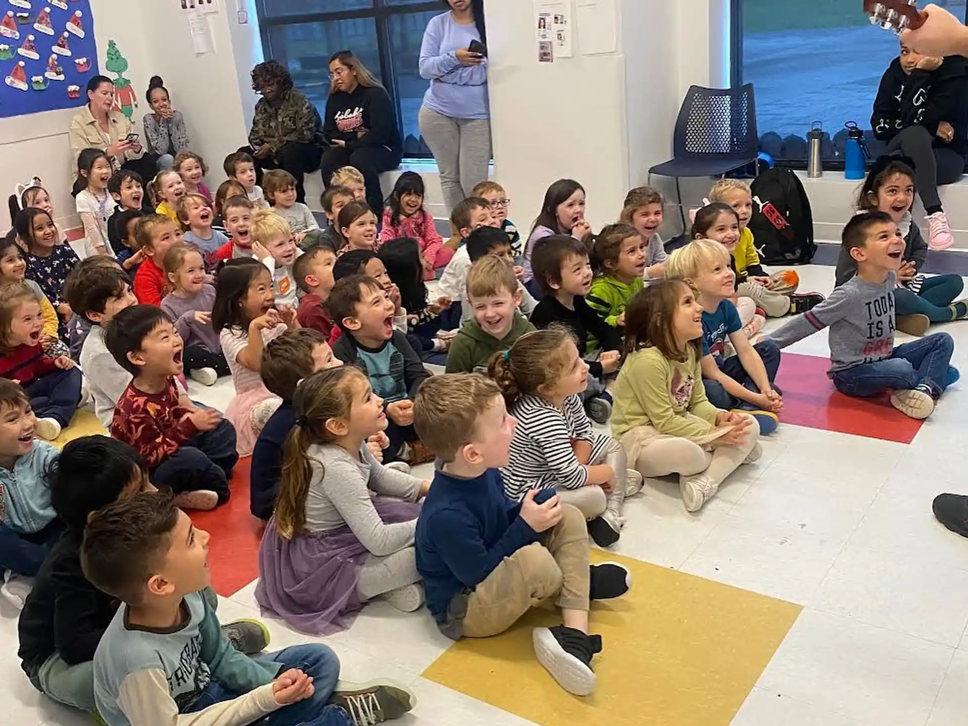 a group of children sitting on the floor in front of a person