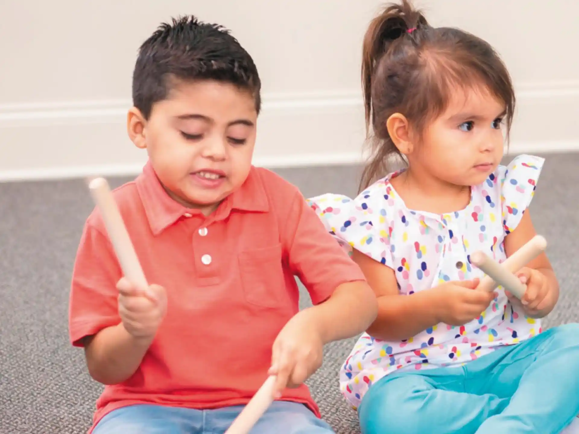 a boy and girl sitting on the floor