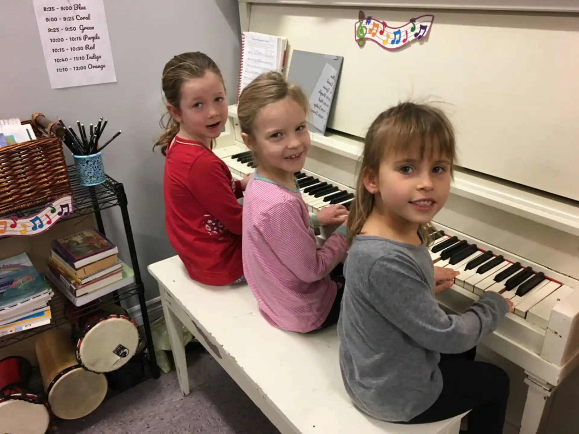 a group of children playing a piano