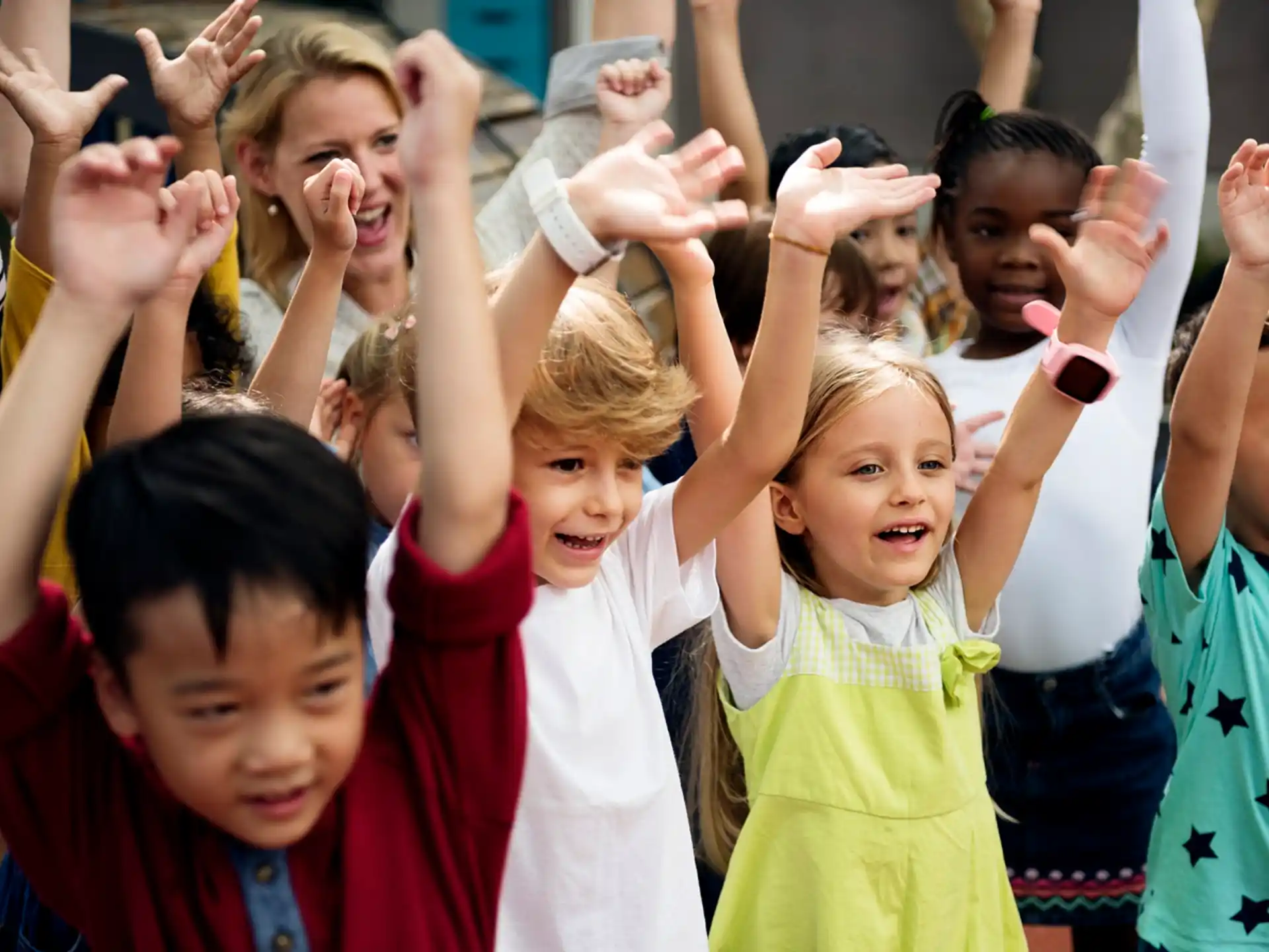 a group of children raising their hands