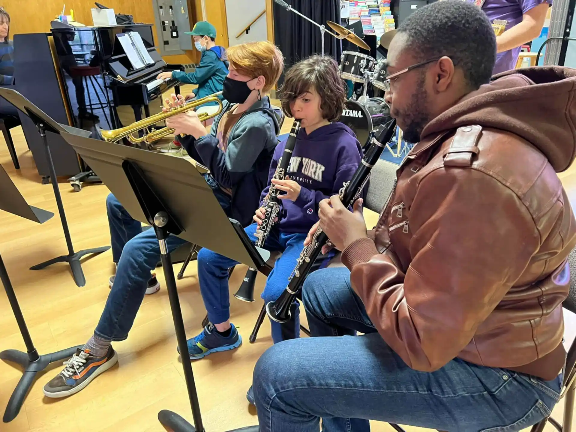 a group of people sitting at desks playing instruments